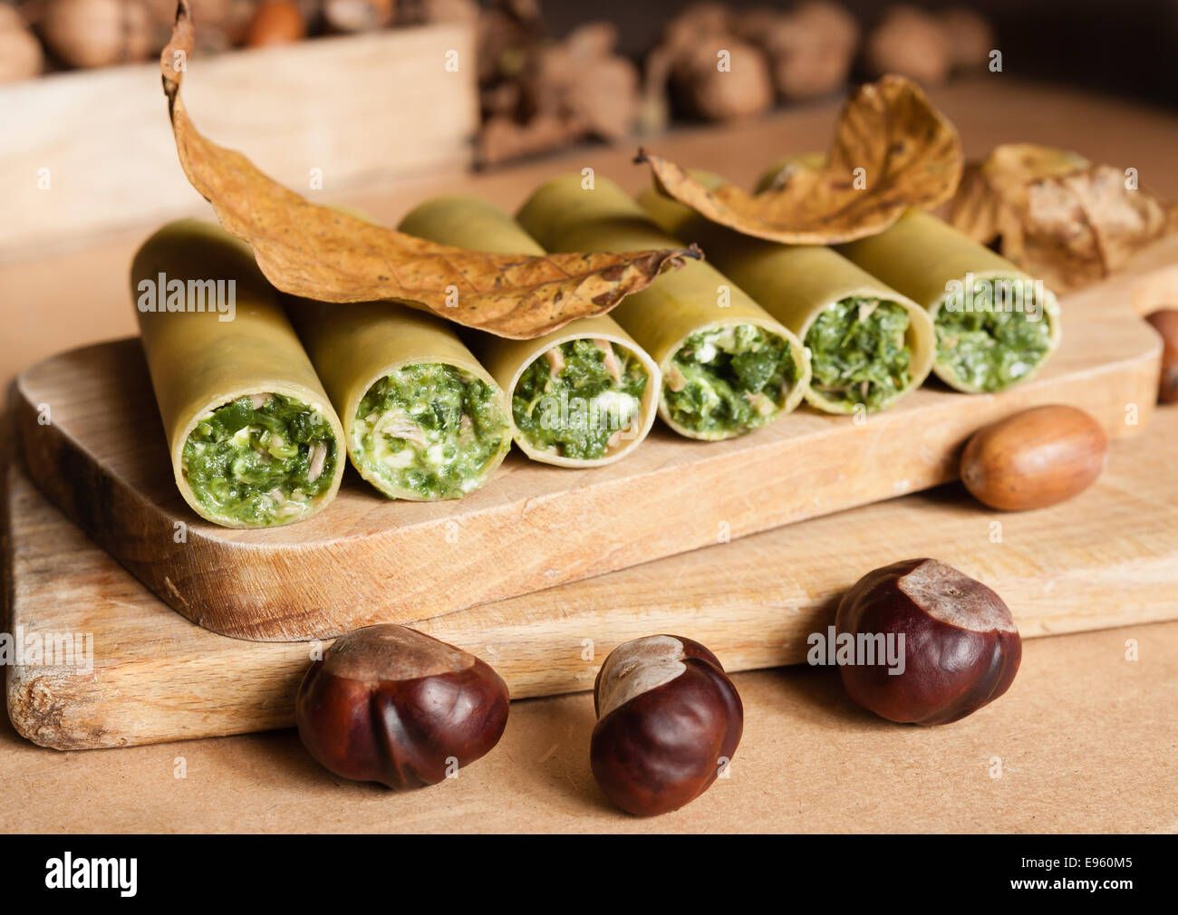 Materie cennellioni pasta spinaci e mozzarella formaggio come vegan o vegetariano su tavola di legno con decorazione di autunno Foto Stock