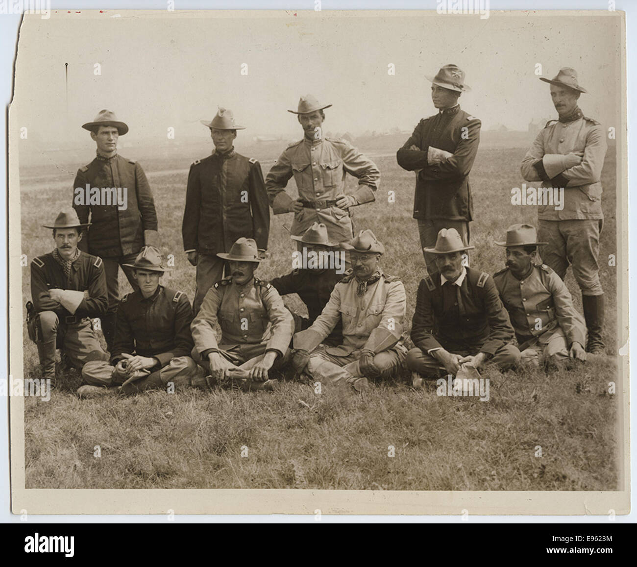 Una fotografia storica del colonnello Theodore Roosevelt con un gruppo di Rough Riders, consigliata per la promozione. L'immagine mostra Roosevelt e i suoi uomini in abbigliamento militare, simboleggiando il loro coinvolgimento nella guerra ispano-americana. Foto Stock