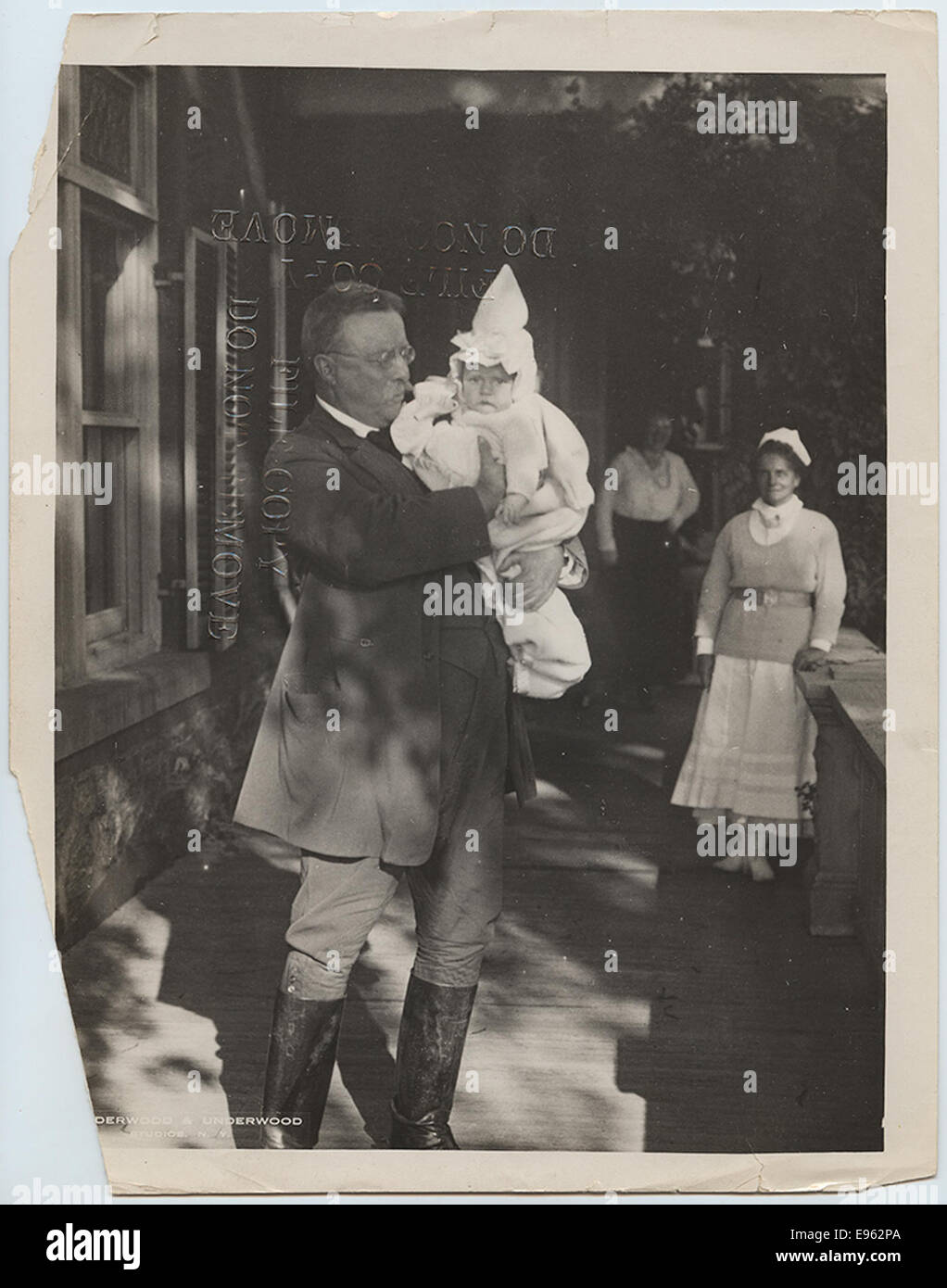Una famosa fotografia del presidente Theodore Roosevelt che tiene suo nipote a Sagamore Hill. Scattata durante la sua permanenza nella sua residenza a Oyster Bay, New York, l'immagine cattura il lato familiare del 26° presidente, giustapposto alla sua nota personalità politica. Foto Stock
