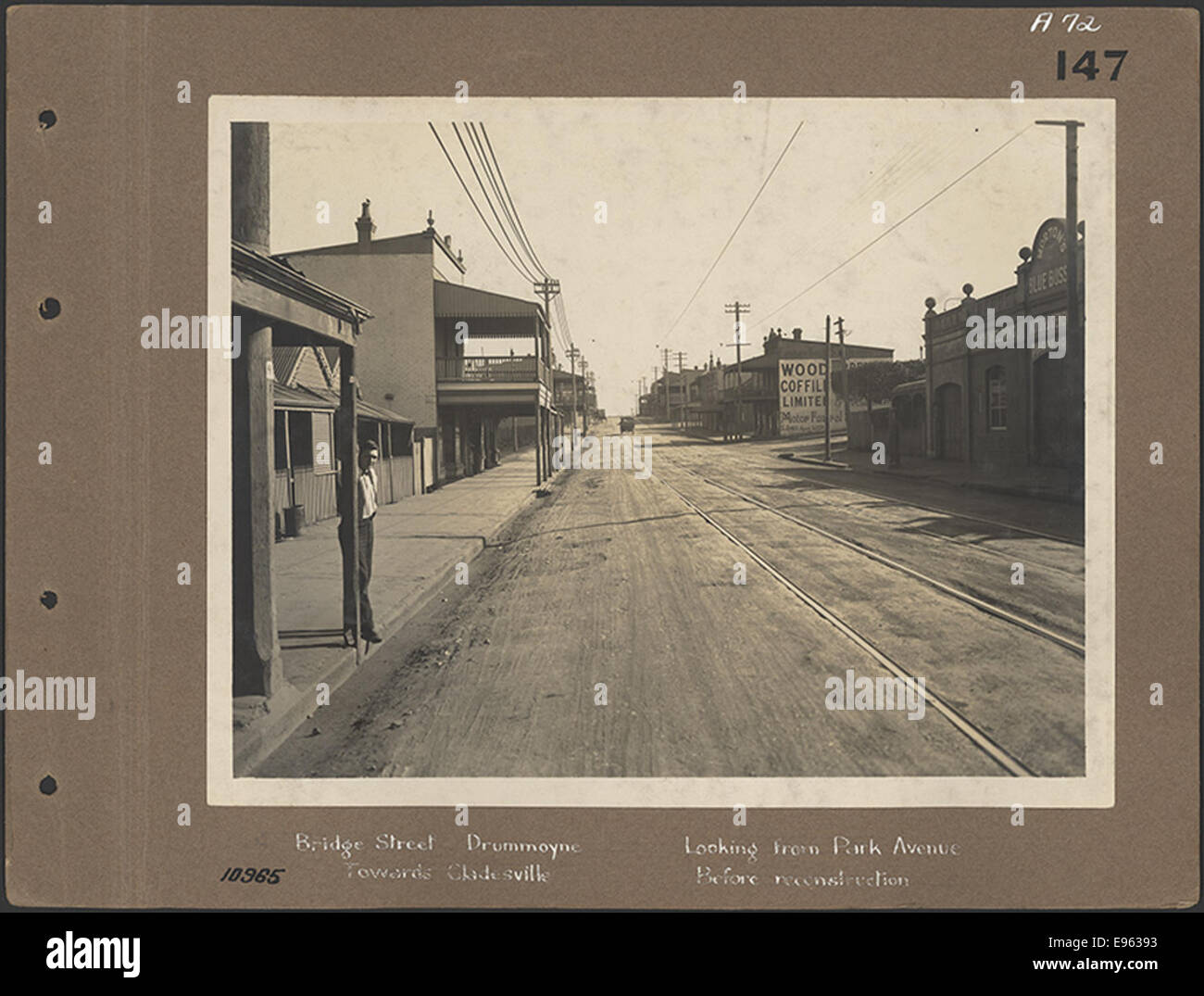 Questa fotografia storica mostra Bridge Street a Drummoyne, Sydney, catturata da Park Avenue guardando verso Gladesville. L'immagine è stata scattata prima della ricostruzione dell'area, mostrando il layout e l'architettura originali della strada. Foto Stock