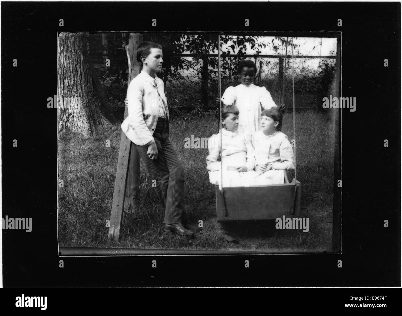 Una fotografia che si crede mostri bambini che giocano sul prato di Myrtle Bank, con uno o più bambini neri. L'immagine probabilmente cattura un momento di vita quotidiana o di svago durante questo periodo. Foto Stock