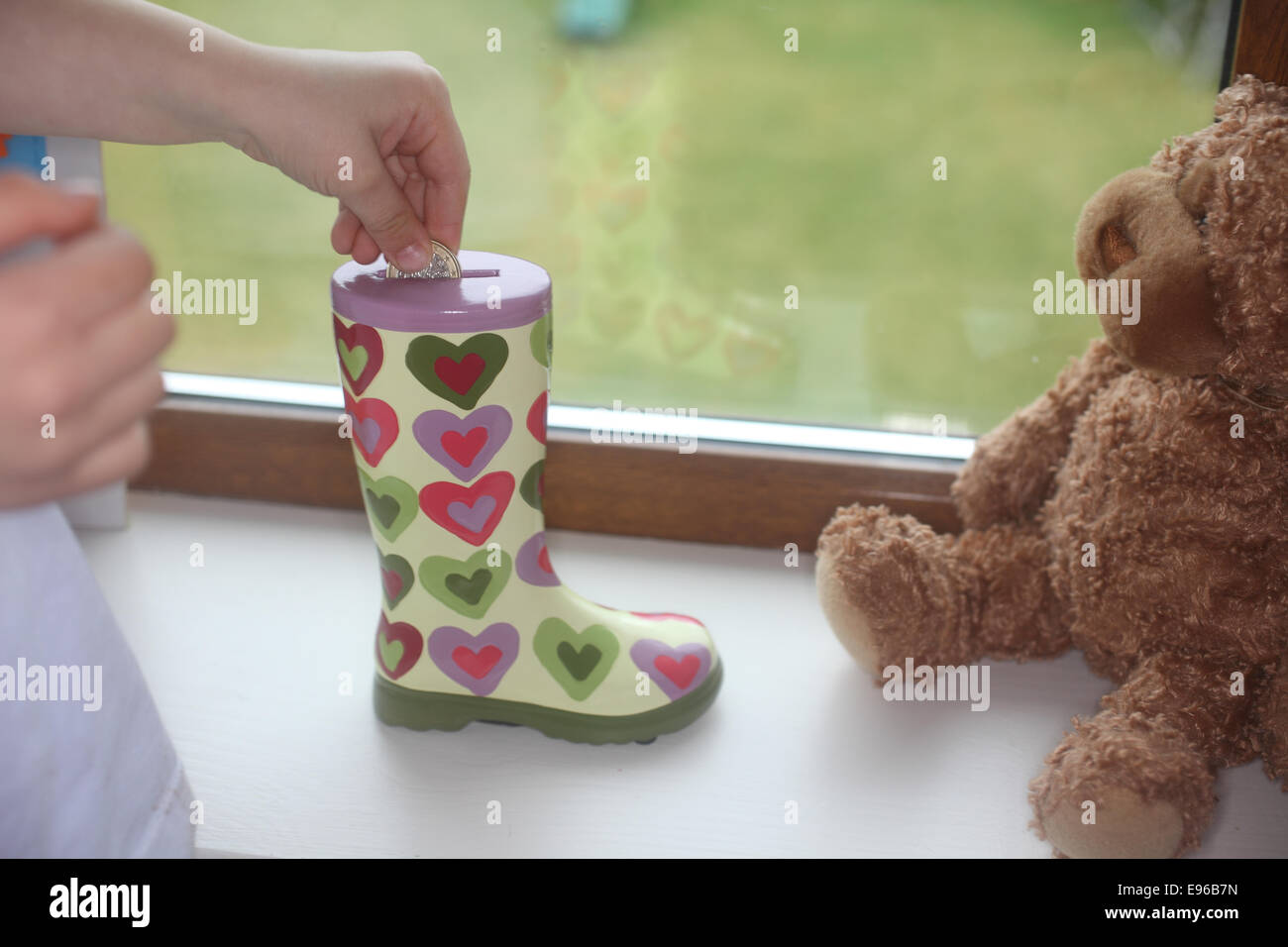 Canto mettere soldi in forma di gamba coin bank Foto Stock