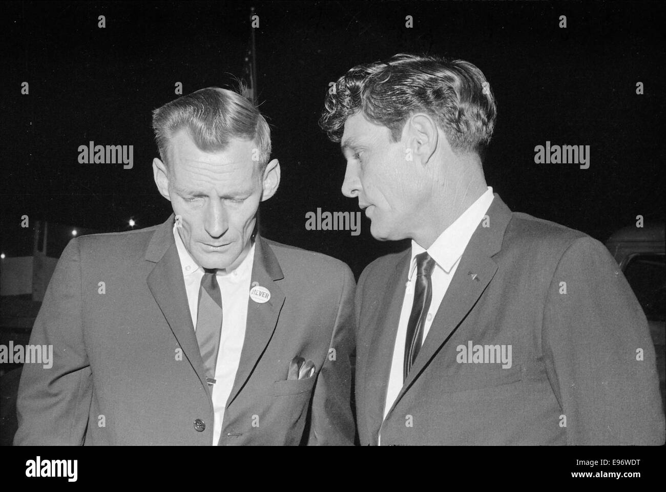 Questa fotografia cattura un raduno del Ku Klux Klan (KKK) tenutosi nel 1965, che documenta i membri del gruppo di supremazia bianca nel bel mezzo della loro manifestazione. L'immagine riflette le tensioni razziali e i disordini sociali degli anni '1960 negli Stati Uniti, segnando un'era di lotte per i diritti civili e disuguaglianza razziale. Foto Stock