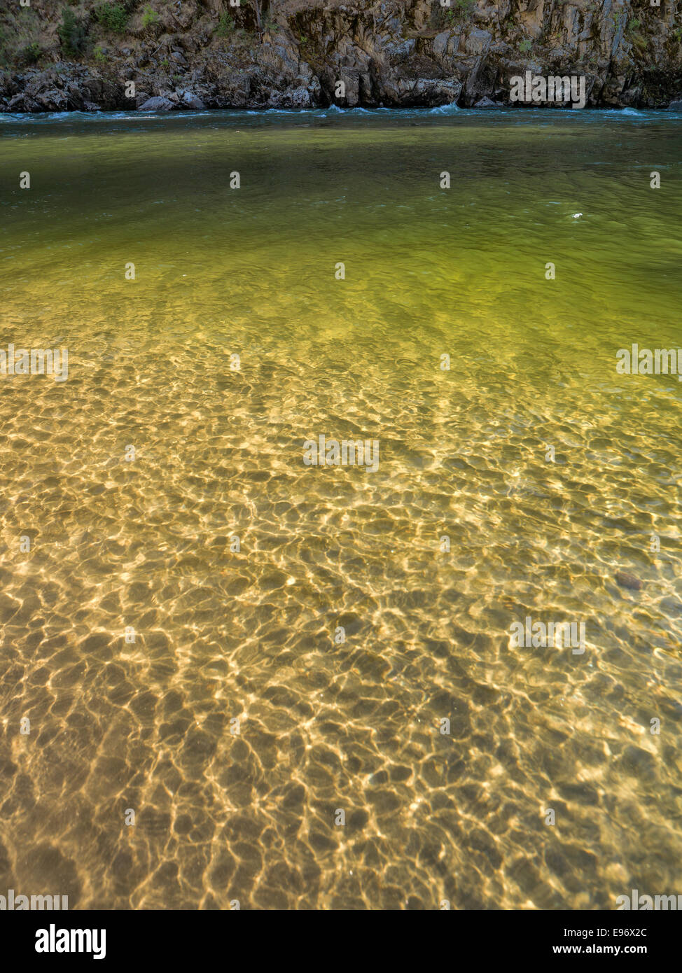 Luce dorata si riflette sul litorale lontano attraverso il fiume da salmone dall'osso T Camp. Foto Stock