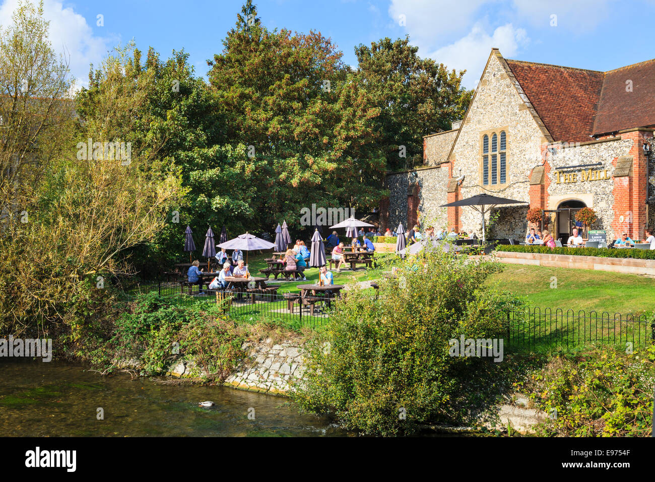 I clienti al di fuori seduta godendo il sole dal mulino Public House lungo il fiume Avon a Salisbury city centre. Foto Stock