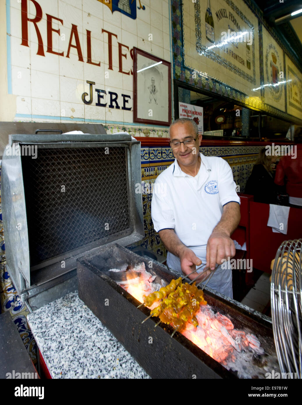 Cafe Iruna a Bilbao, Spagna uomo rendendo "pinchos morunos' spiedini con prosciutto e spezie Foto Stock