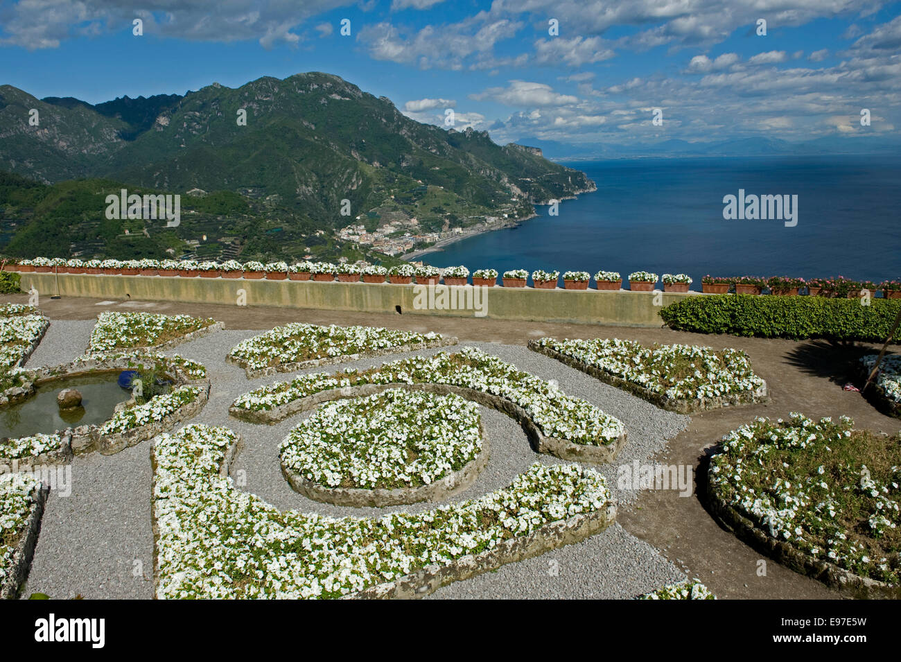 Le aiuole e un laghetto nei giardini di Villa Rufolo a Ravello guardando oltre la Costiera Amalfitana e il Golfo di Salerno ho Foto Stock