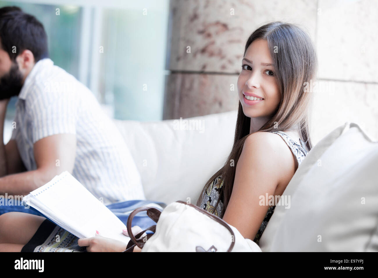 Femmina studente universitario si siede in cafe azienda appunti Foto Stock