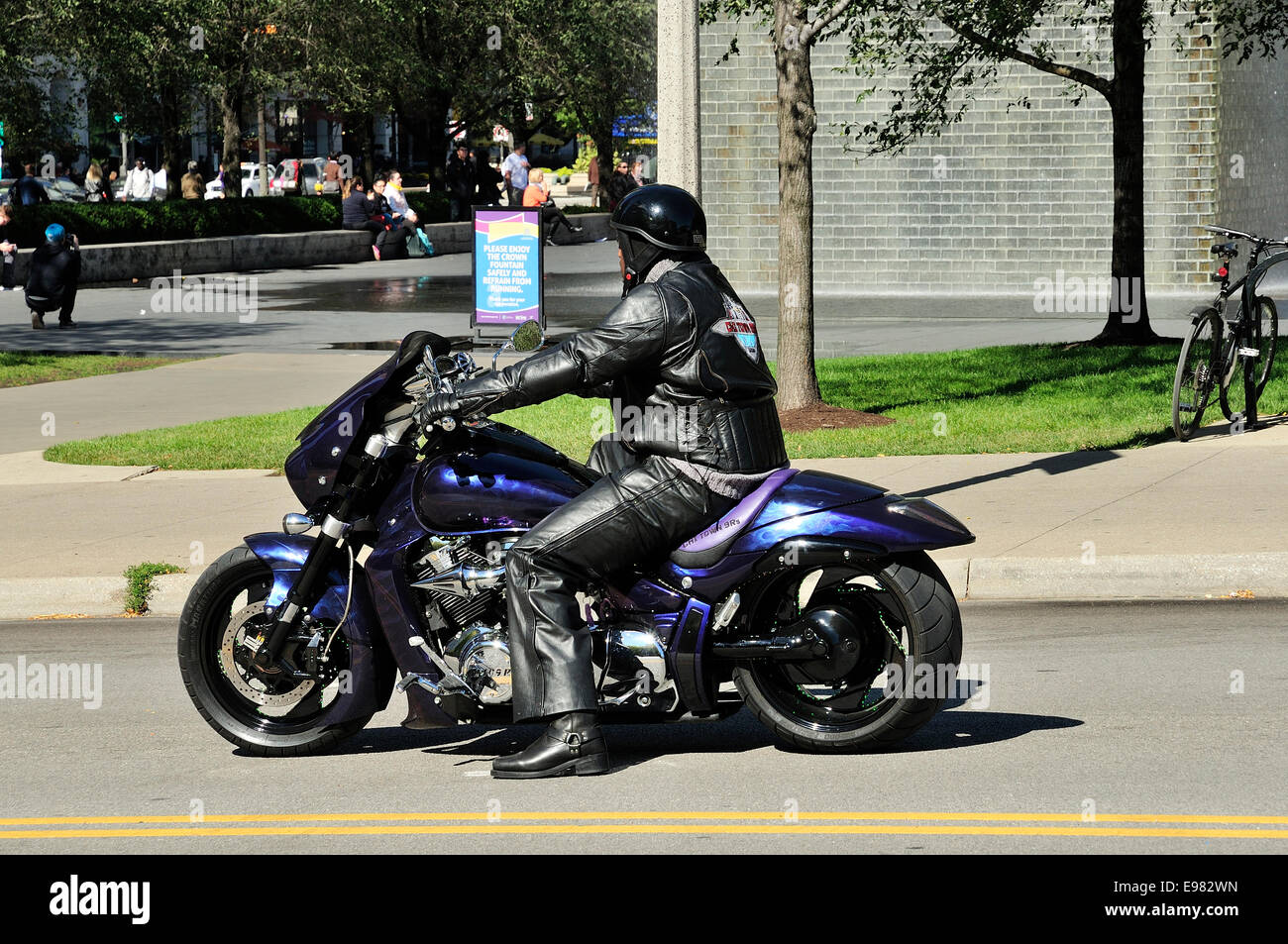Un rivestito in pelle uomo nero sulla motocicletta personalizzata su Monroe Street in Chicago Foto Stock