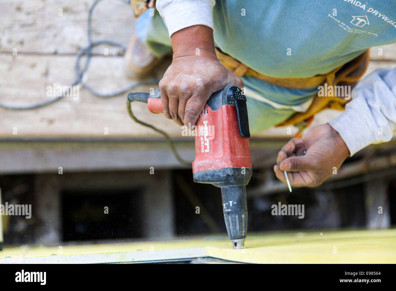 Lavoratore installazione sistema parete materiali e isolamento sopra il telaio della casa residenziale. Los Angeles, California, Stati Uniti d'America Foto Stock