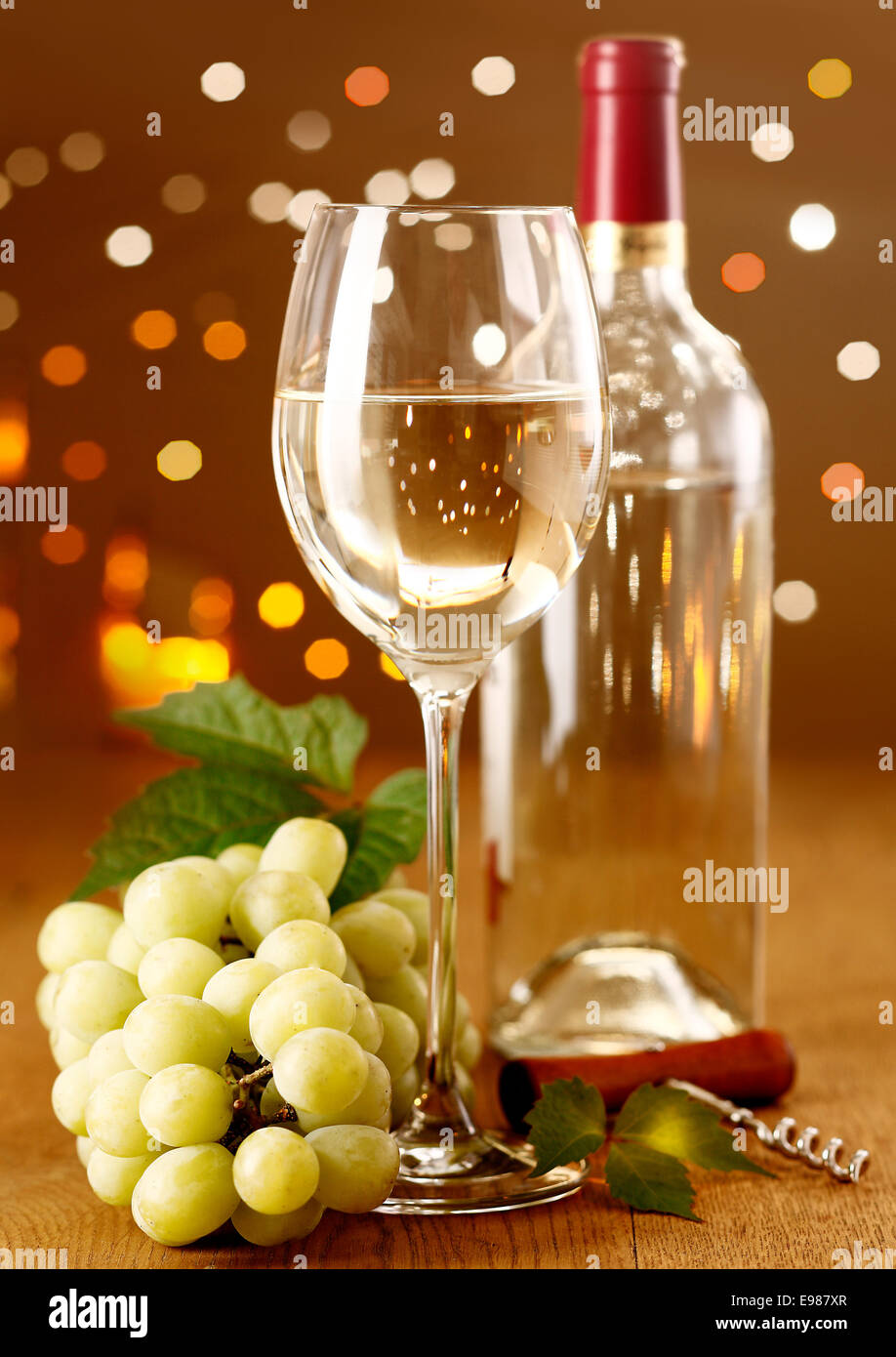 Elegante vino bianco con uve su un sfondo di festa con belle Boketh Foto Stock