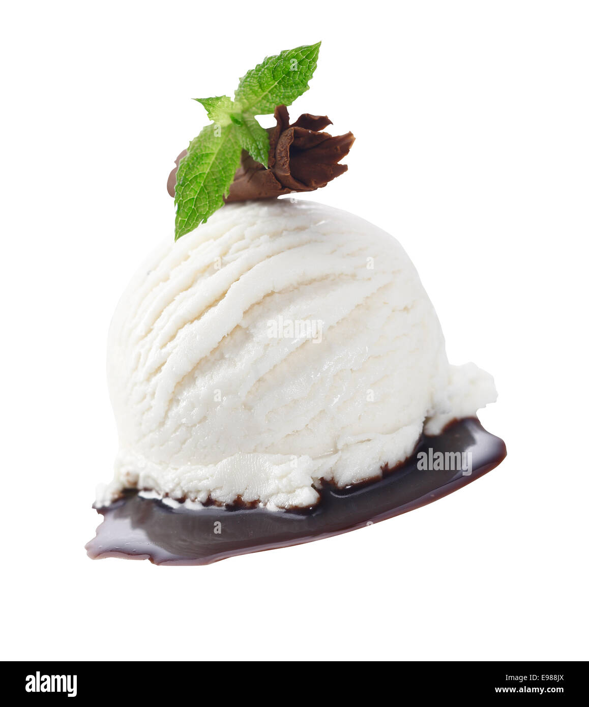 Scoop di cremoso gelato alla vaniglia servito con salsa di cioccolato e guarnita con un laminato di rasatura il cioccolato al latte e foglie di menta Foto Stock