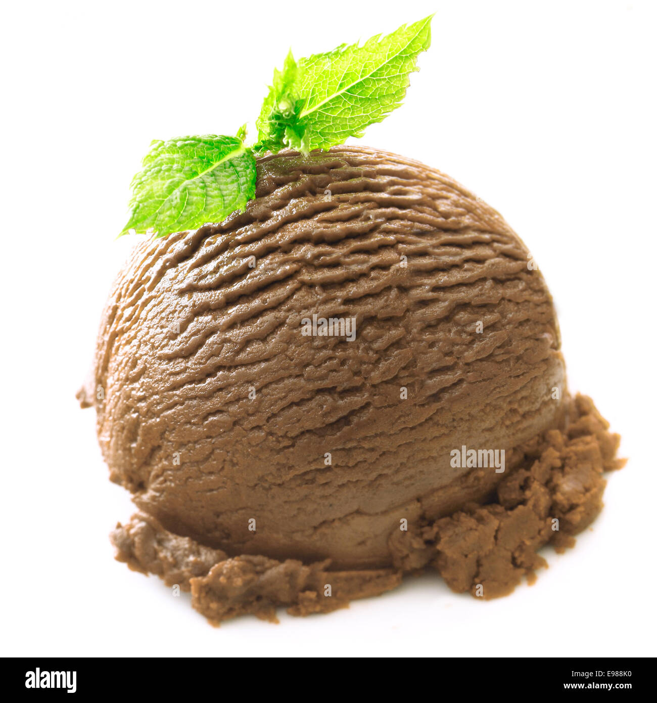 Primo piano di un delizioso cioccolato ricco gelato sfera guarnito con menta su bianco Foto Stock