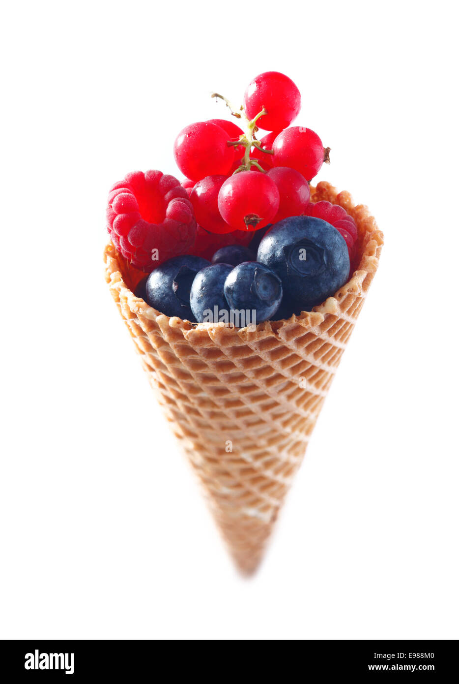 Un assortimento di frutta mix in un cono gelato. Mirtilli lamponi e ribes in uno spazio vuoto sullo sfondo bianco Foto Stock