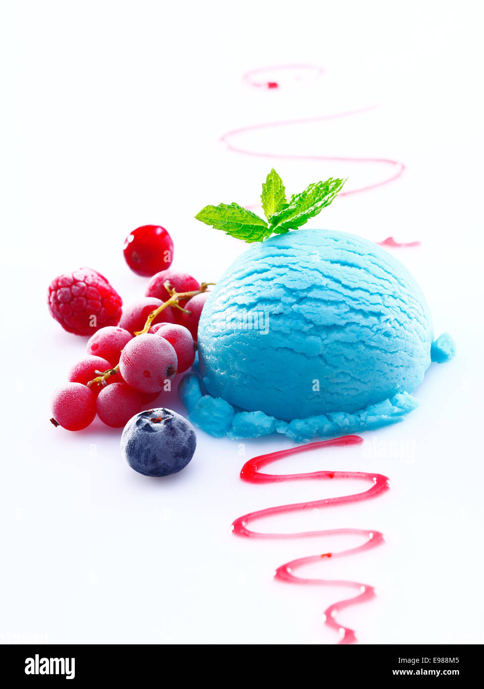 Cremosa di mirtillo di gelato con una spruzzata di sciroppo e di un accompagnamento di fresco Ribes rosso e lamponi Foto Stock