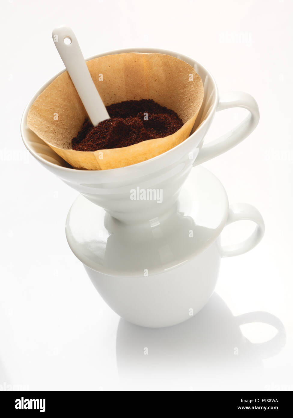Portable carta bianca comune e nuova Cina imbuto filtrante con carta da filtro riempito con caffè macinato fresco e un cucchiaio di misurazione Foto Stock