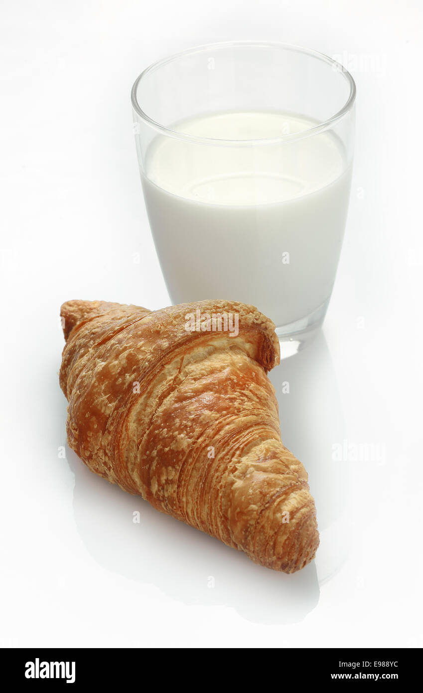 Studio shot di un bicchiere di latte fresco e un cornetto su sfondo bianco Foto Stock