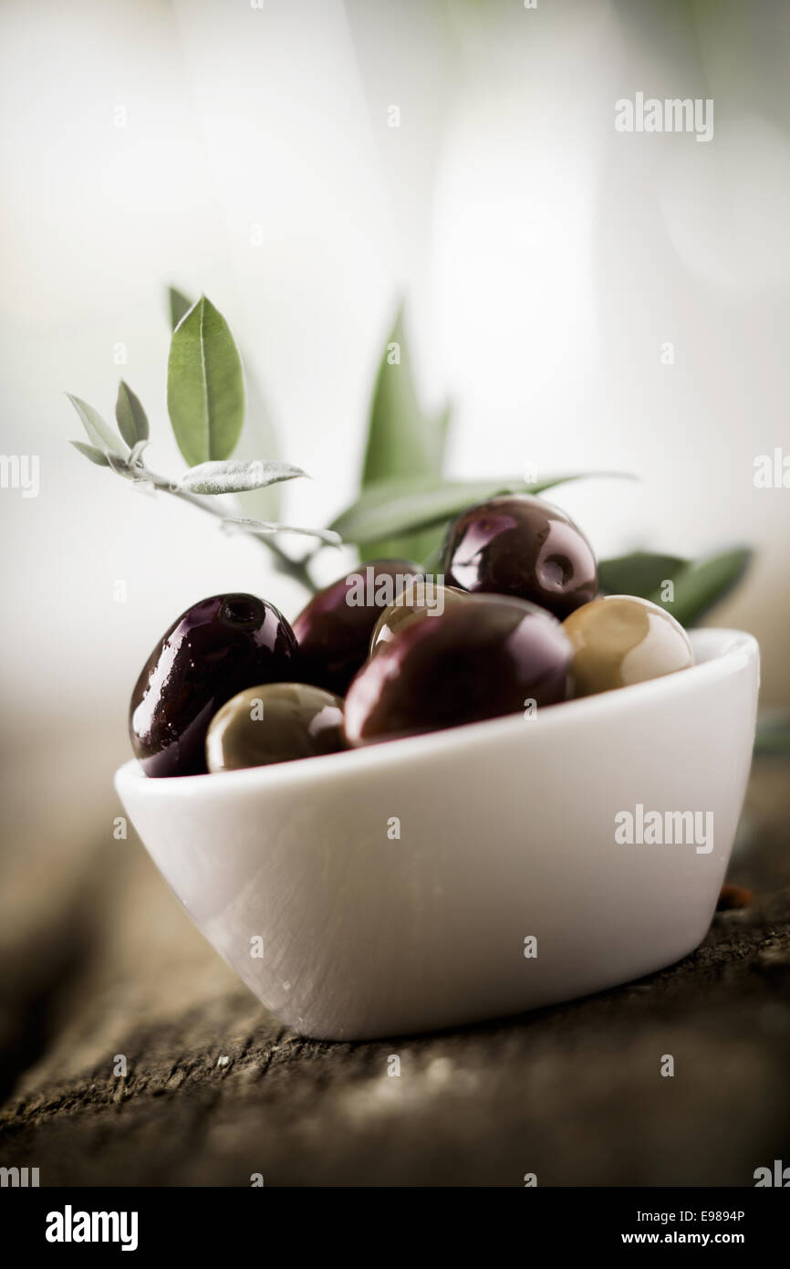 Vista inclinata di una ciotola di fresco di olive nere con shallow dof e copyspace Foto Stock