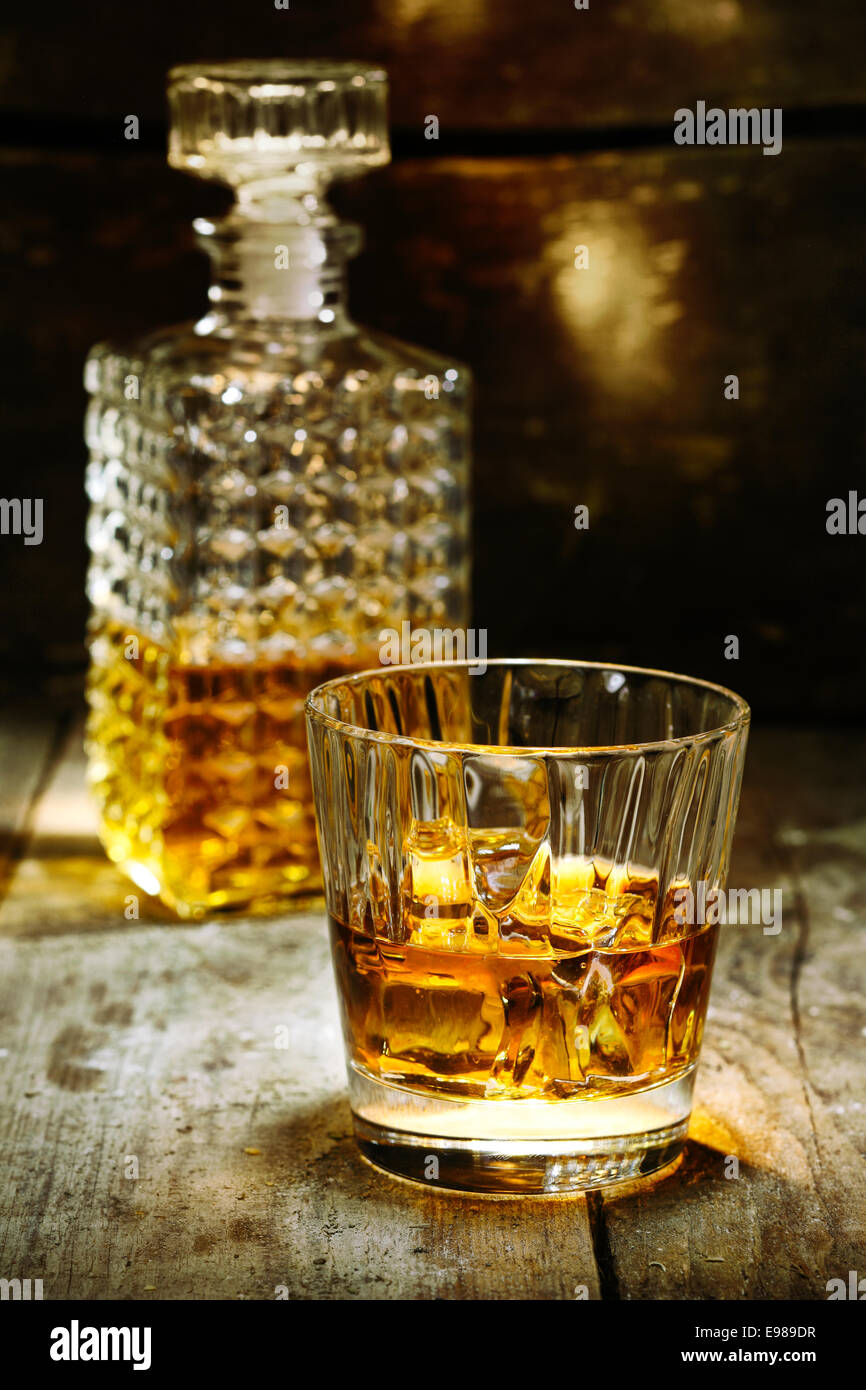 Vetro e bottiglia di liquore duro come scothc, bourbon whiskey o brandy su sfondo di legno con copyspace Foto Stock