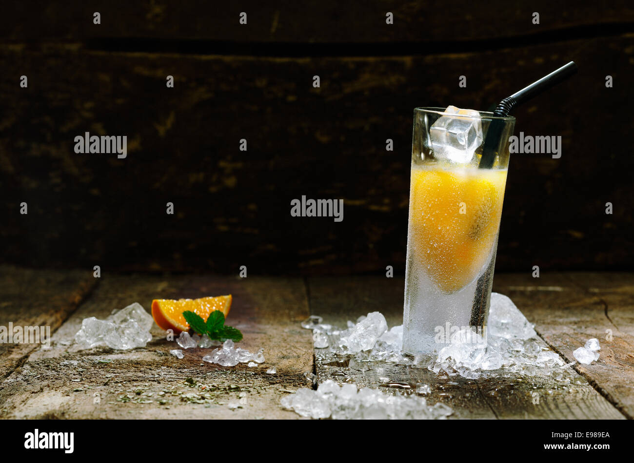 L'alcol Orange Shot Drink con copyspace, marrone sulla tavola di legno. Foto Stock