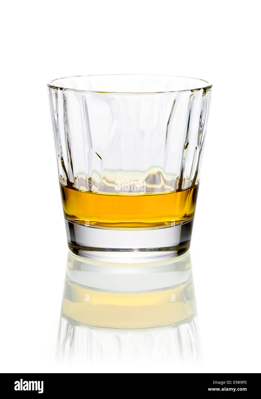 Rilassante rinfrescante bicchiere di whisky o brandy in un bicchiere su sfondo bianco con la riflessione Foto Stock