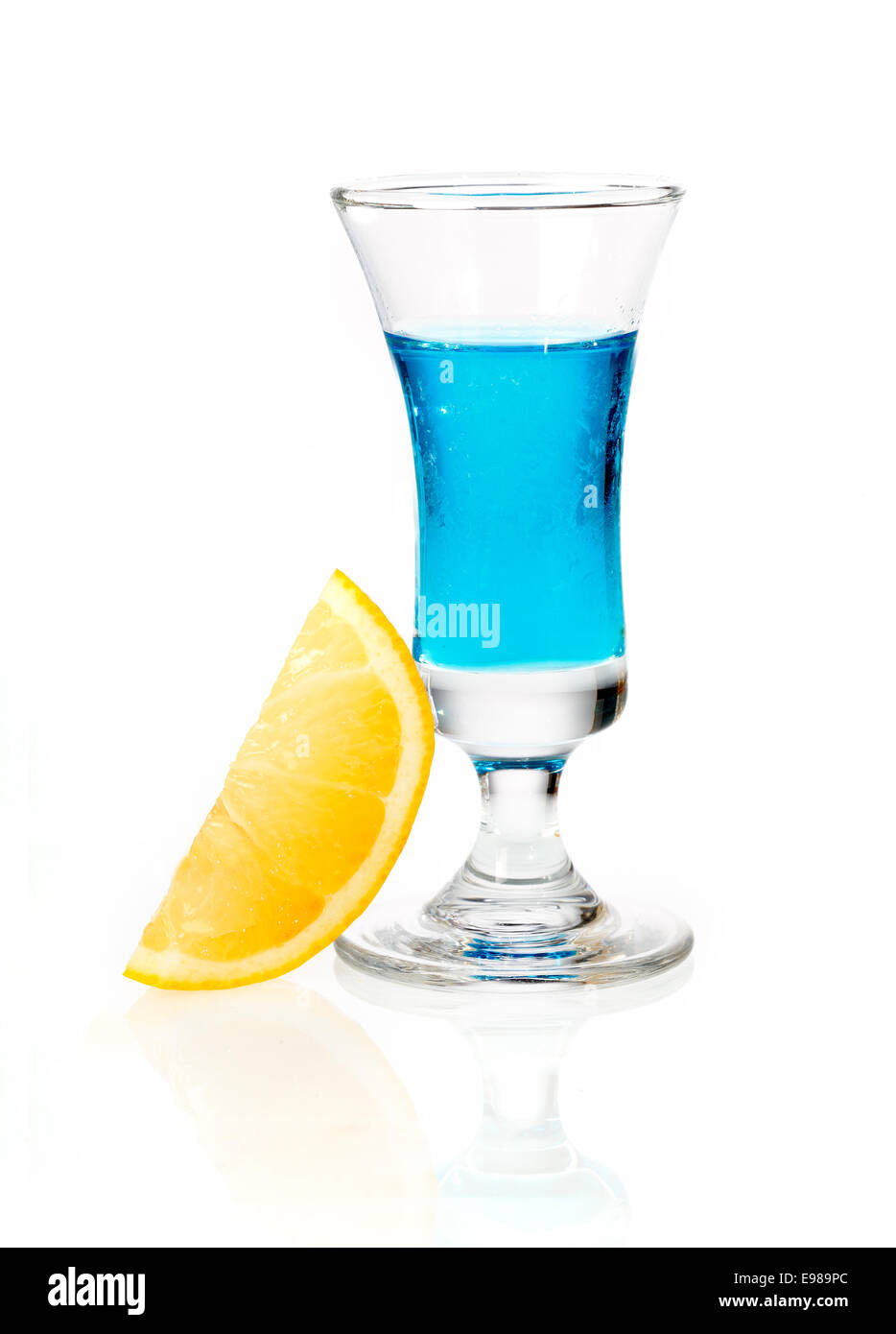 Colpo di vetro di curacao blu liquore all'arancia guarnire su un bianco sfondo riflettente Foto Stock
