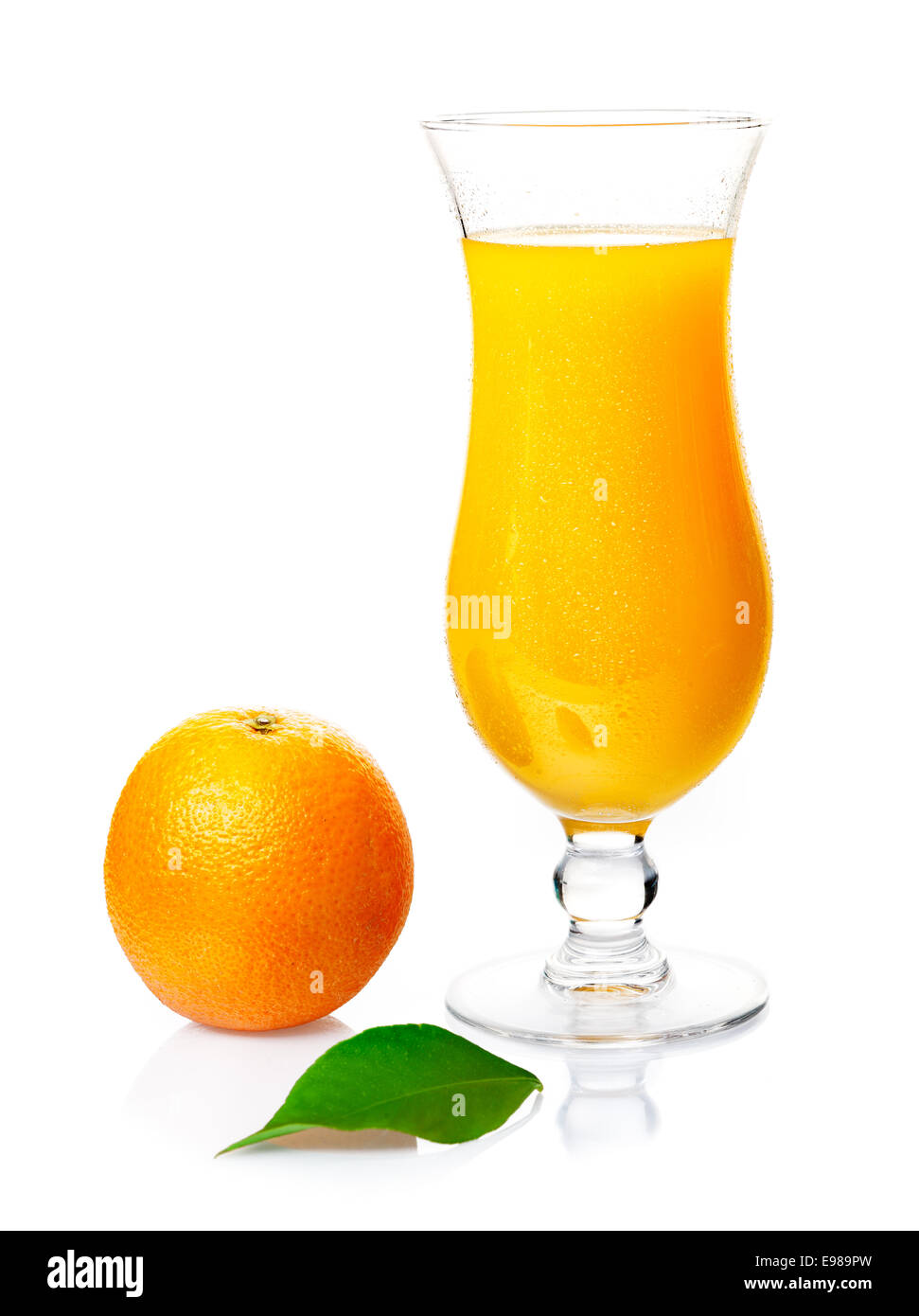 Bicchiere di deliziosi salutare spremuta di arancia fresca in un elegante bicchiere con un frutto intero a fianco su una bianca di sfondo per studio Foto Stock