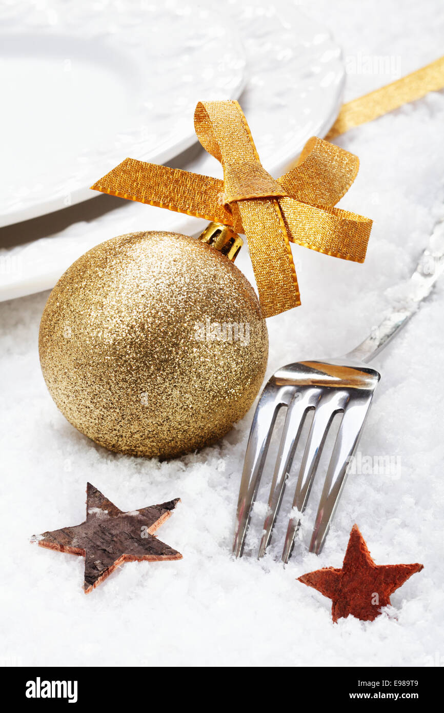 Natale inverno impostazione posto sulla neve con posate in argento decorato con una pallina d'oro e stelle Foto Stock