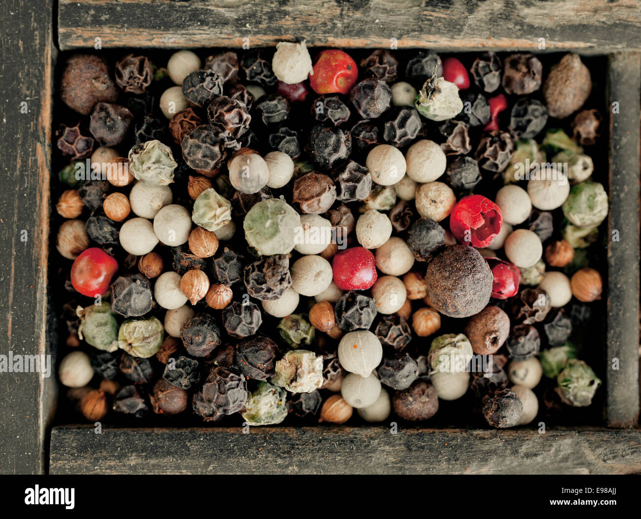Vista aerea assortiti di grani di pepe misto con interi essiccati nero, bianco e rosso o pepe rosa utilizzato come un caldo pungente spezie e condimenti Foto Stock