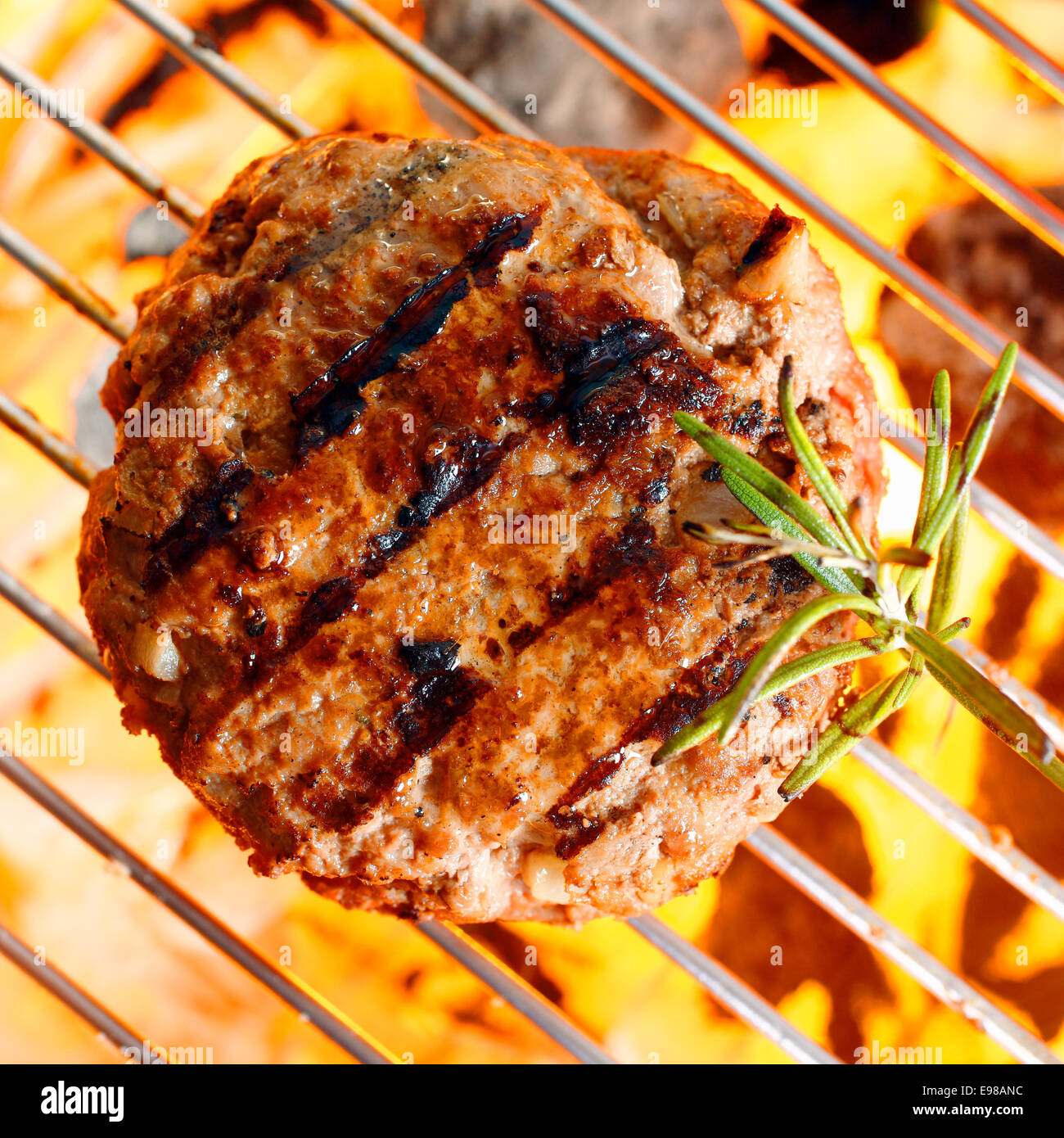 Hamburger patty sulla padella per grigliare con fiamme libere Foto Stock