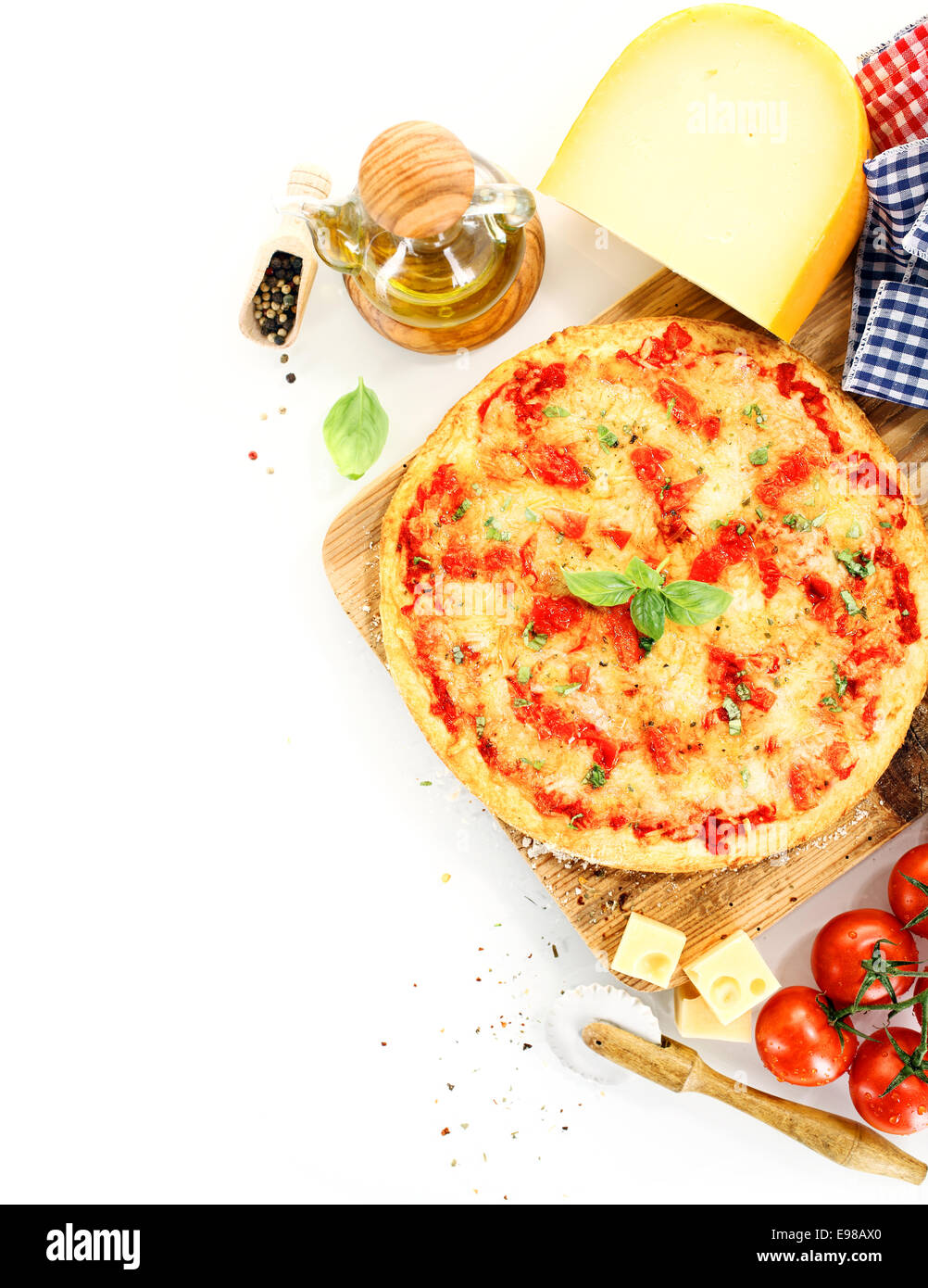 Vista dall'alto di una pizza Margherita circondato da ingredienti come il pomodoro, formaggio, basilico, olio di oliva e pepe e utensili per la cucina Foto Stock