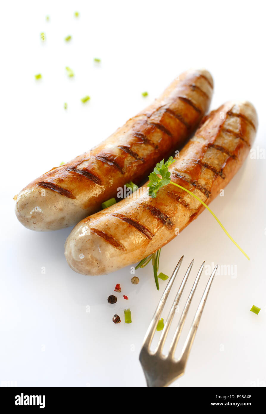 Due salsicce alla griglia e la forcella in una immagine ravvicinata Foto Stock