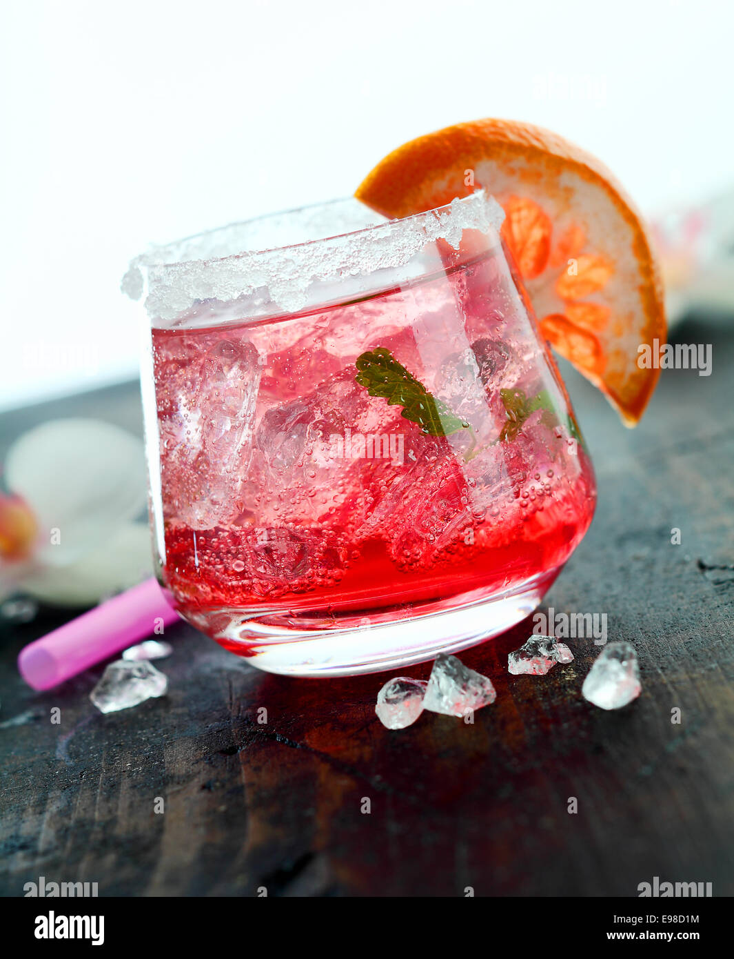 Di ghiaccio freddo daiquiri cocktail servito in un bicchiere guarnito con orange su una barra di legno counter Foto Stock