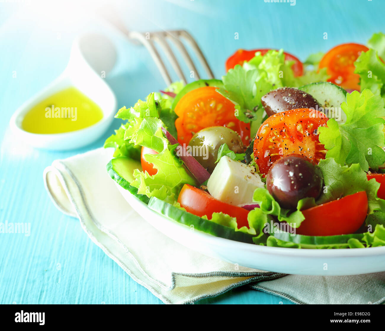 Primo piano di una piastra di sani e freschi greco feta e olive con insalata di lattuga croccante e pomodoro per una deliziosa cucina mediterranea Foto Stock