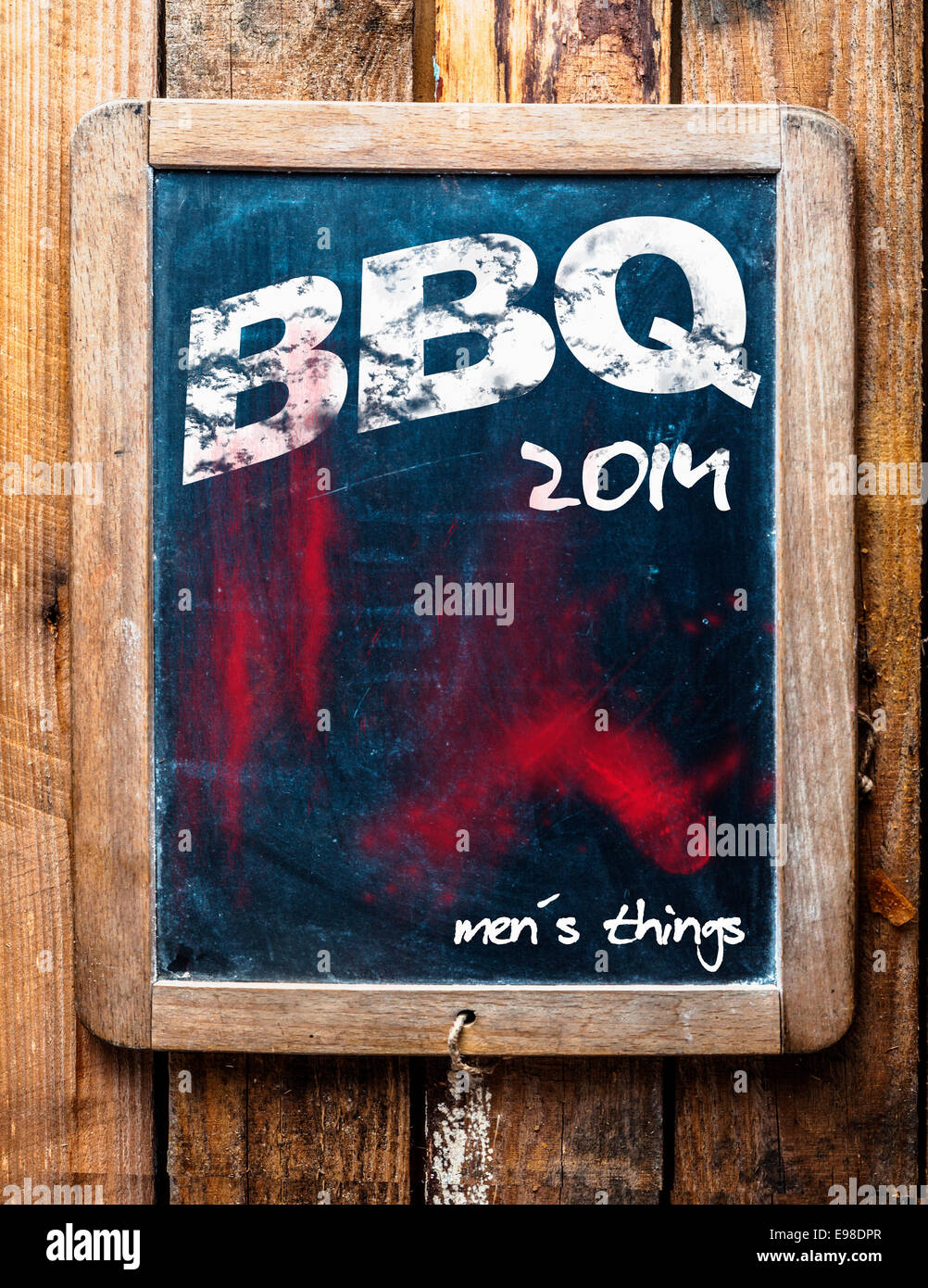 Barbeque pubblicizzato su una vecchia scuola vintage ardesia in un grunge telaio in legno su un tavolo rustico con un addendum al fondo dicendo - Le Mans stuff Foto Stock