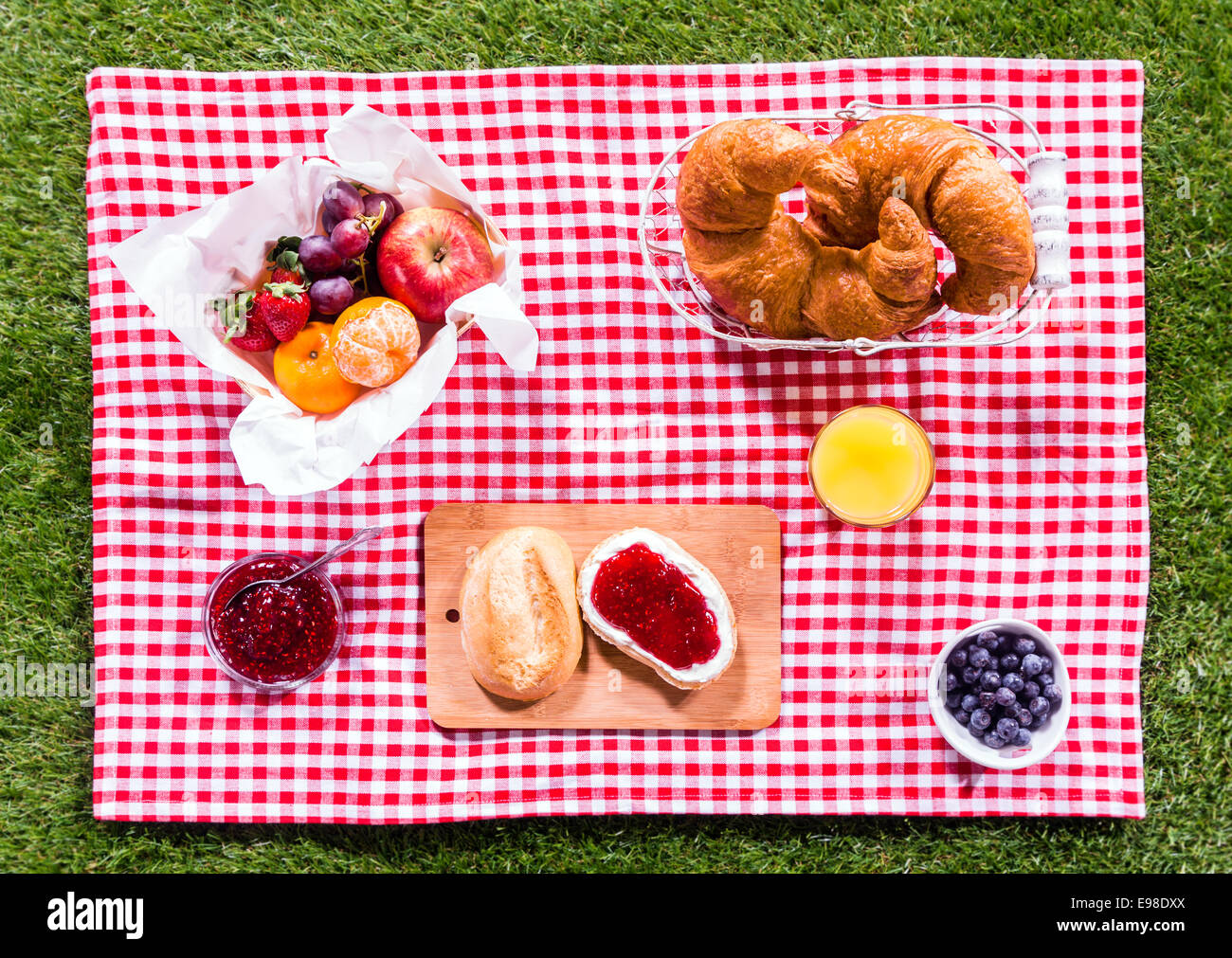 Picnic a cesto in vimini con il cibo sulla tavola di legno sulla spiaggia  con cielo blu di sfondo e sun. Il concetto di picnic. Vista frontale.  Composizione orizzontale Foto stock 