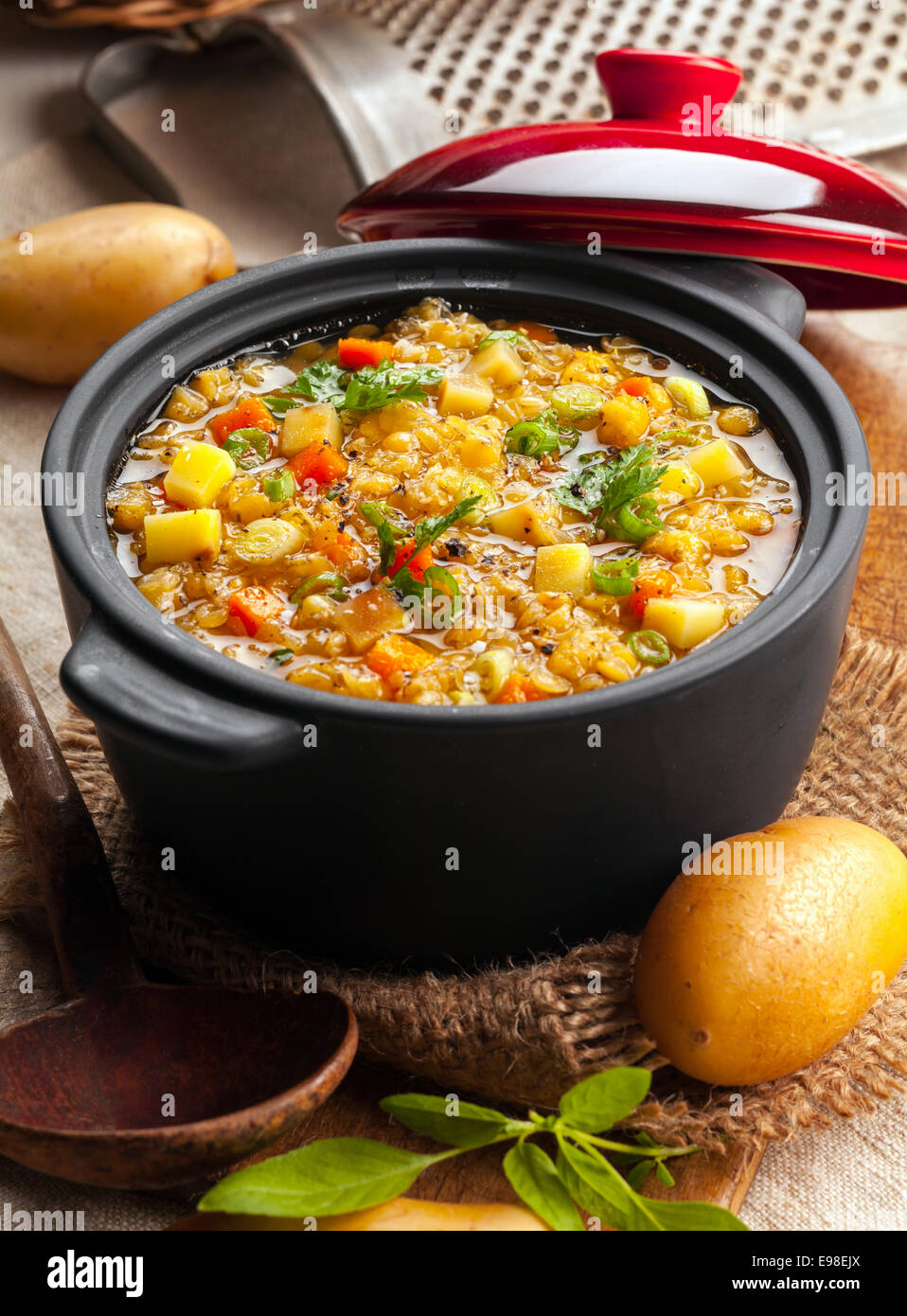 Una deliziosa minestra di ceci e stufato di vegetali in una cucina rustica in un tegame di coccio aperto, ad alto angolo di visione Foto Stock