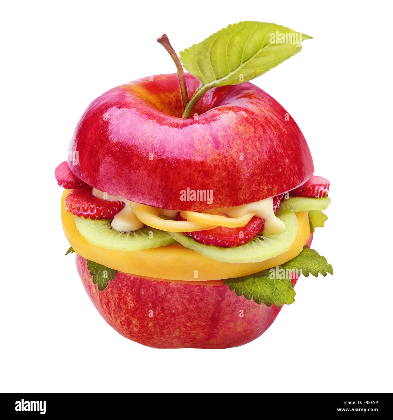 Creative sano succosa mela burger riempito con fette di frutta fresca tropicale, fragole e kiwi spruzzata con una salsa con una singola foglia verde per un basso contenuto calorico snack, isolato su bianco Foto Stock