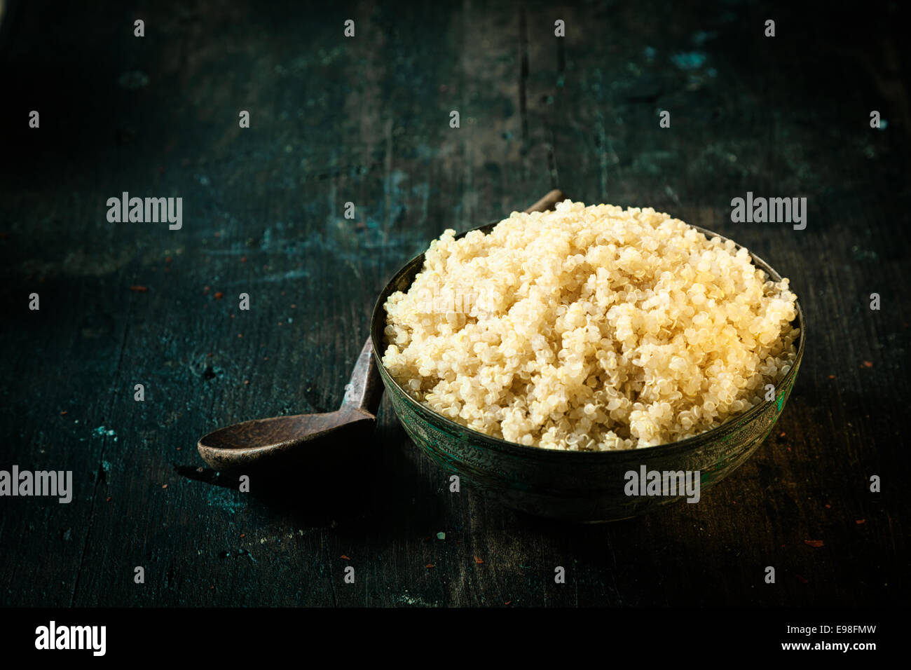 Ciotola di steamed quinoa sani, una pseudo-cereale ricco di proteine salutato come superfood per le sue qualità nutrizionali, su sfondo scuro con copyspace Foto Stock