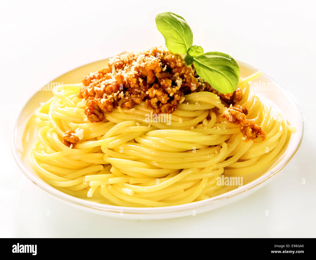 Piastra impilati con un serve piatti tradizionali italiani spaghetti bolognese con basilico fresco e parmigiano grattugiato, vista laterale su bianco Foto Stock