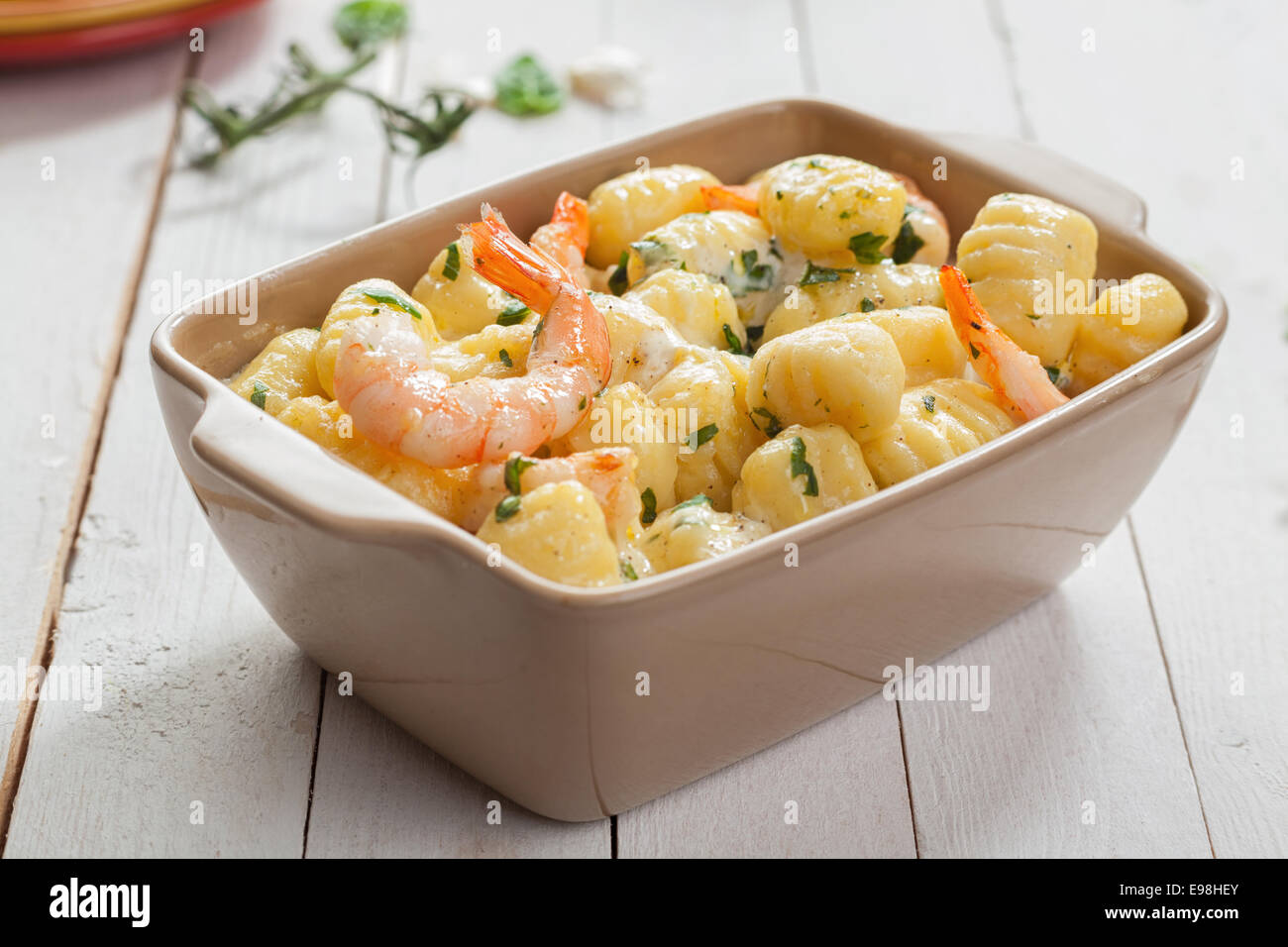Cucina Italiana Cucina a base di pesce alla griglia con Gamberi rosa in gnocchi di pasta, o gnocchi di semolino, servita in una casseruola condita con erbe fresche Foto Stock