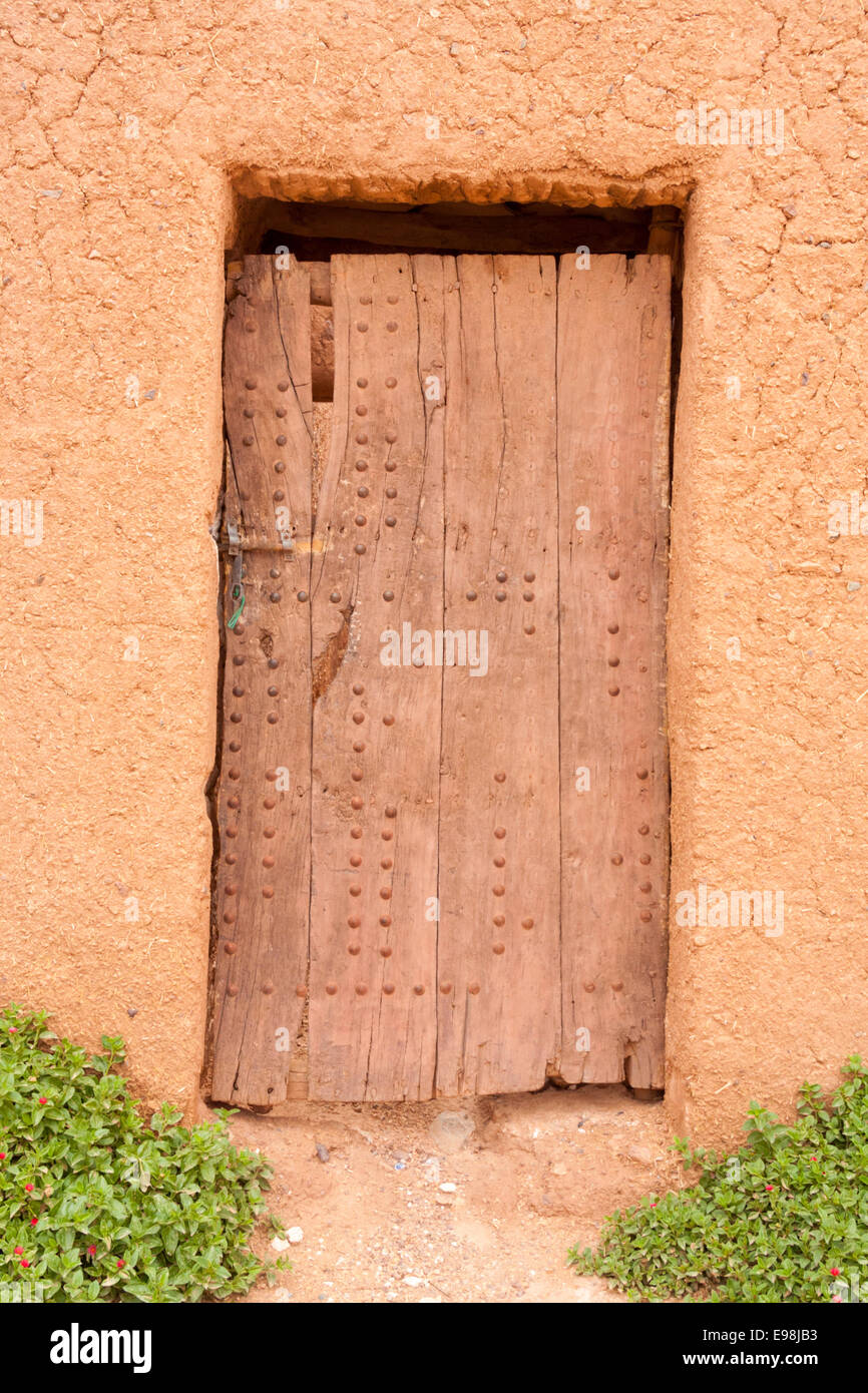Vecchia porta di legno di un tradizionale edificio di argilla nel Patrimonio Mondiale UNESCO città di Ouarzarzate, Marocco Foto Stock