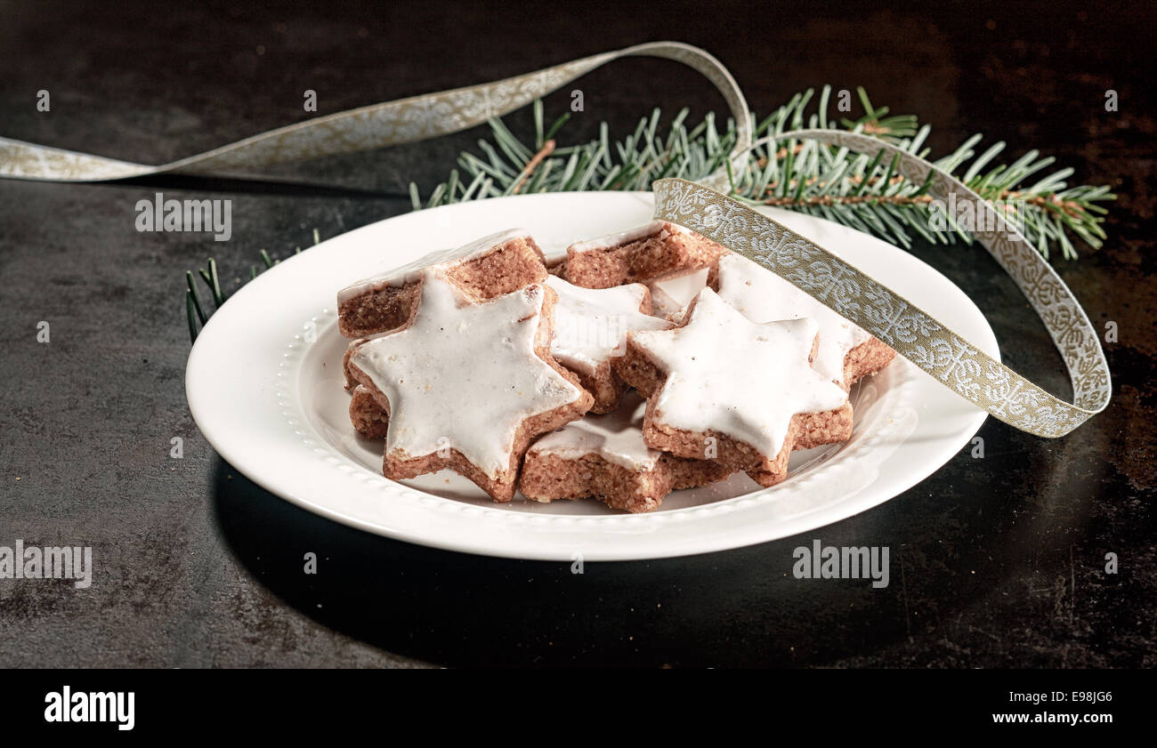 Piatto di deliziosa croccante di stella di Natale biscotti vetrate con glassa bianca per una festosa snack stagionali Foto Stock