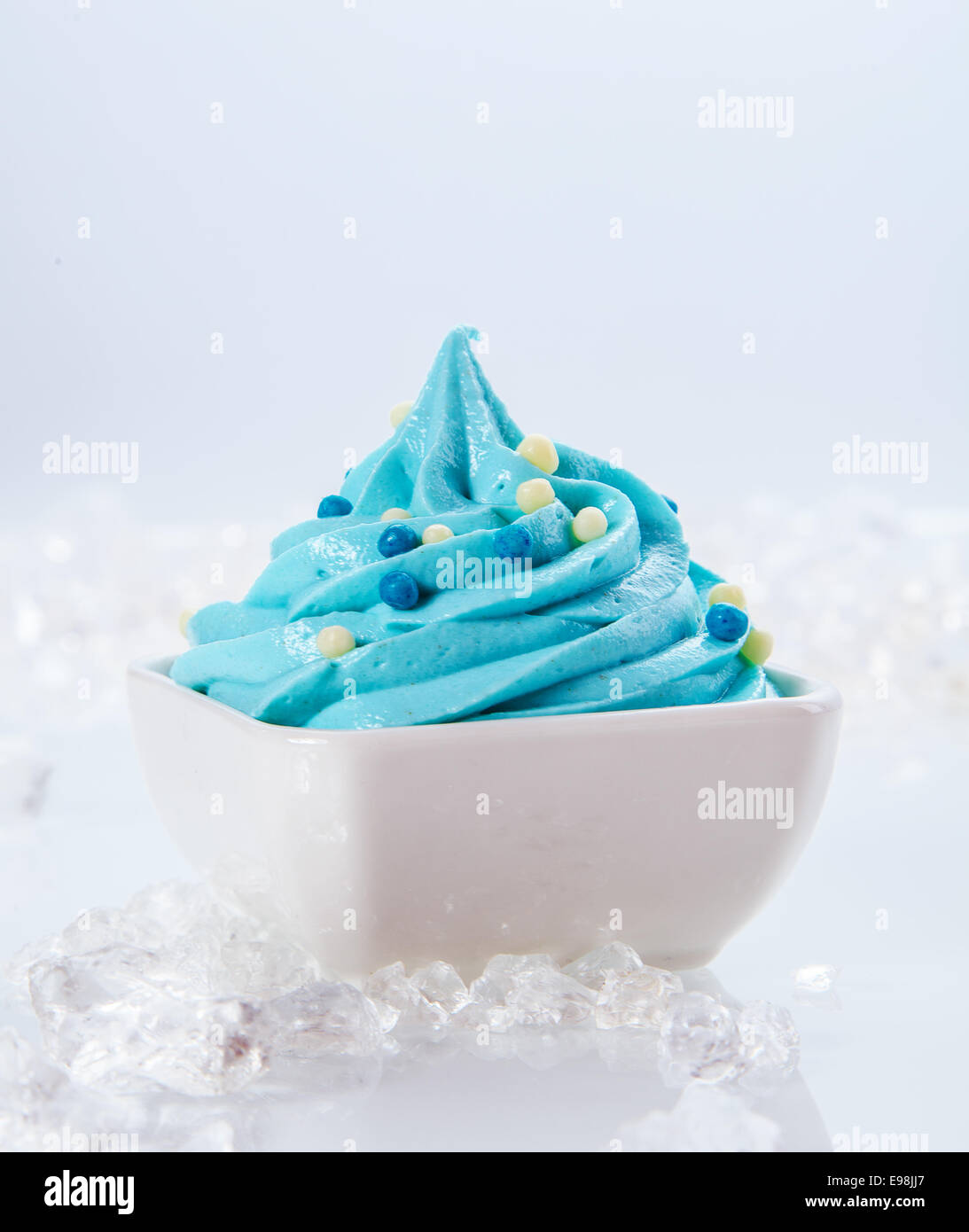 Chiudere fino deliziosi Azzurro Frozen Yogurt su bianco ciotola con pezzi di ghiaccio sui lati. Isolato su sfondo bianco. Foto Stock
