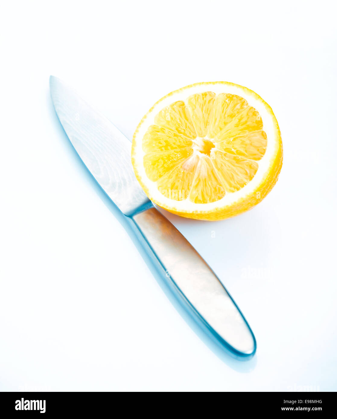 Dimezzato limone fresco per guarnire con un coltello su un bianco bacjground studio Foto Stock