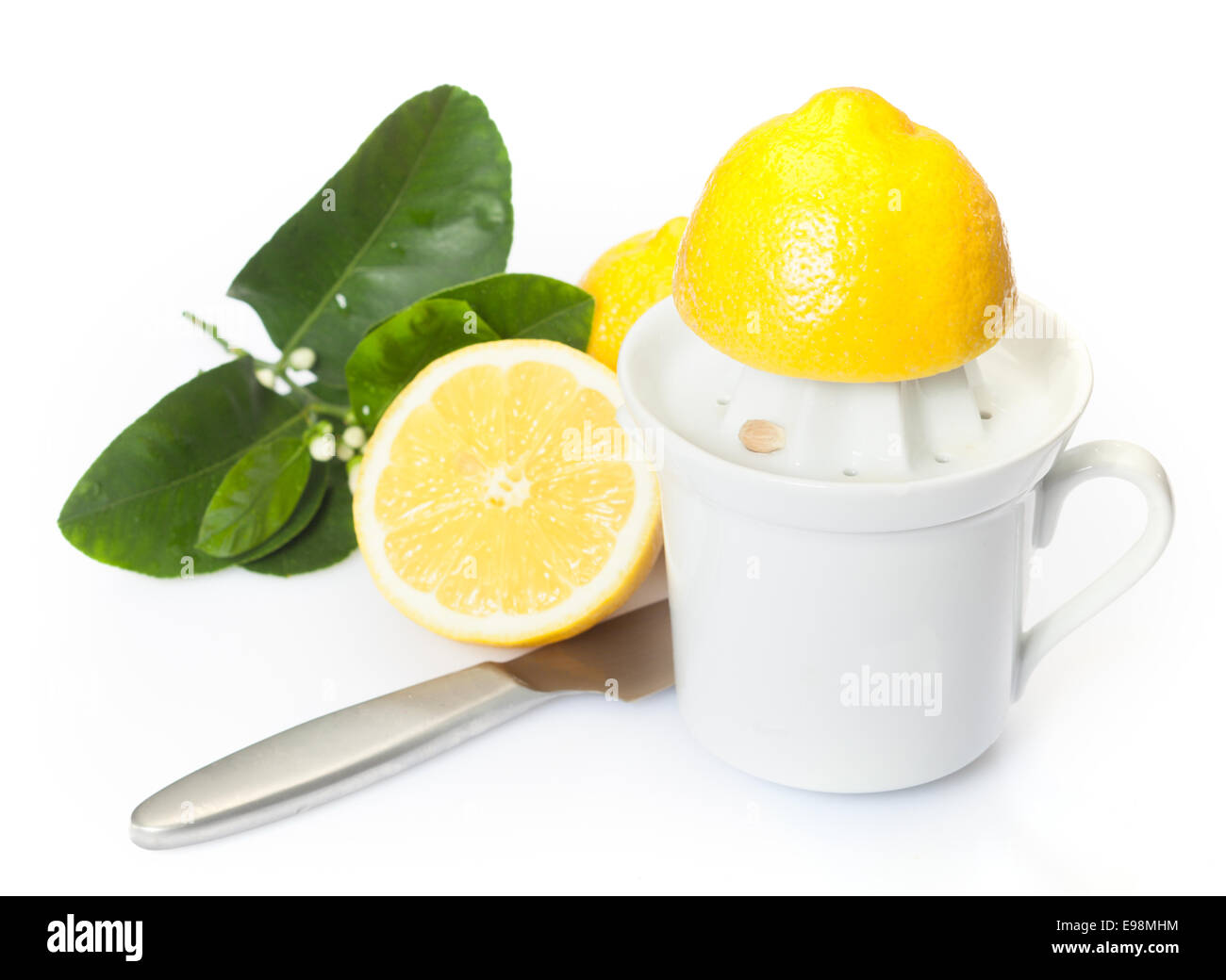 La preparazione di succo di limone fresco per uso come ingrediente in cucina con una metà limone su una centrifuga in plastica Foto Stock
