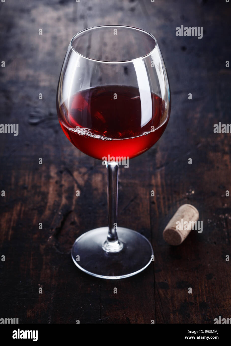 Rosso scuro Merlot o di vino di Borgogna con un tappo di sughero su uno sfondo di legno Foto Stock