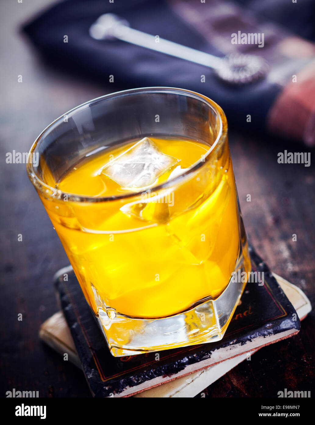 Liquori con succo di arancia in piedi su un coaster, su una tavola di legno, vintage sfondo, per drink e cocktail concetti Foto Stock