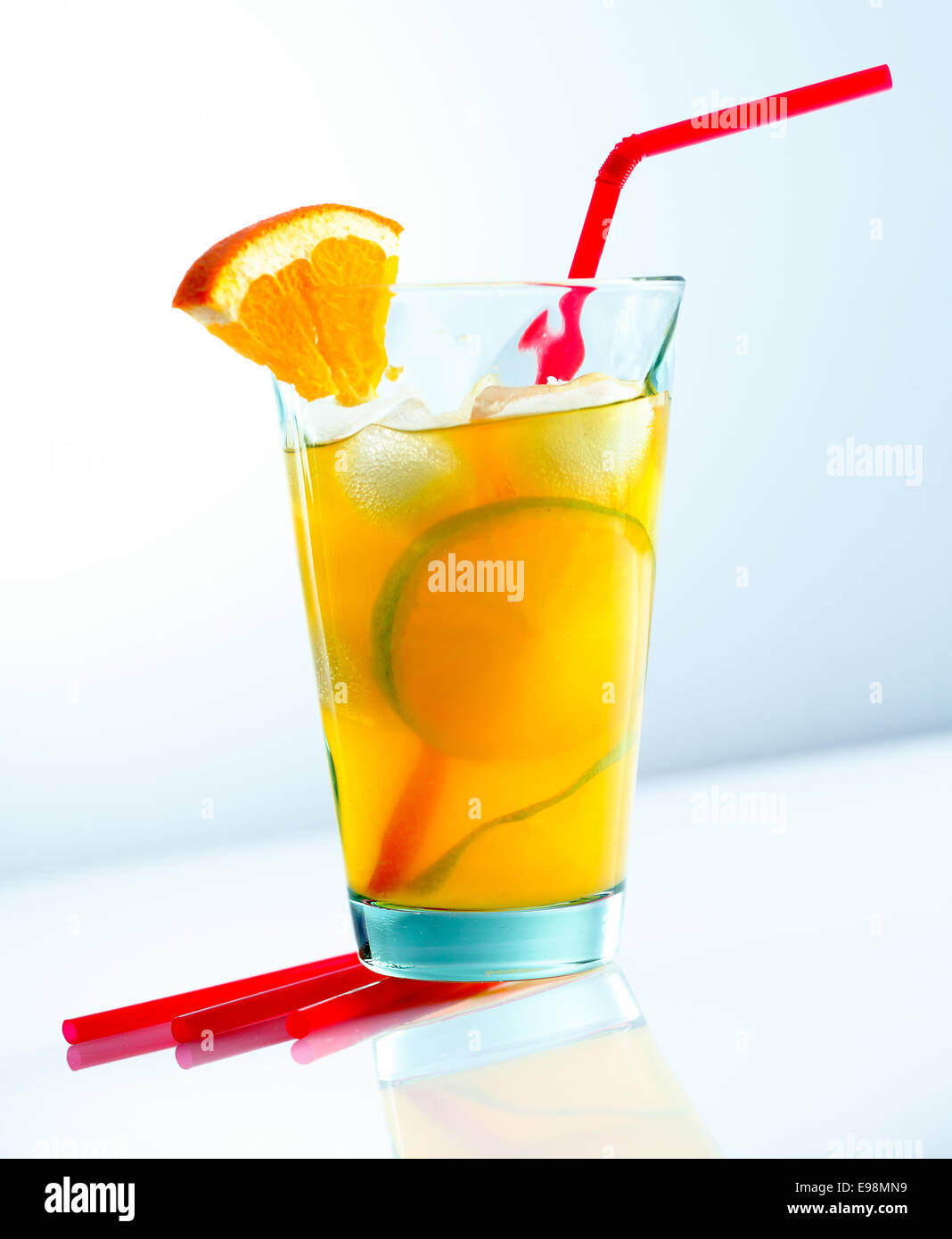 Succosa cocktail con una cannuccia isolati su fondo azzurro. Foto Stock