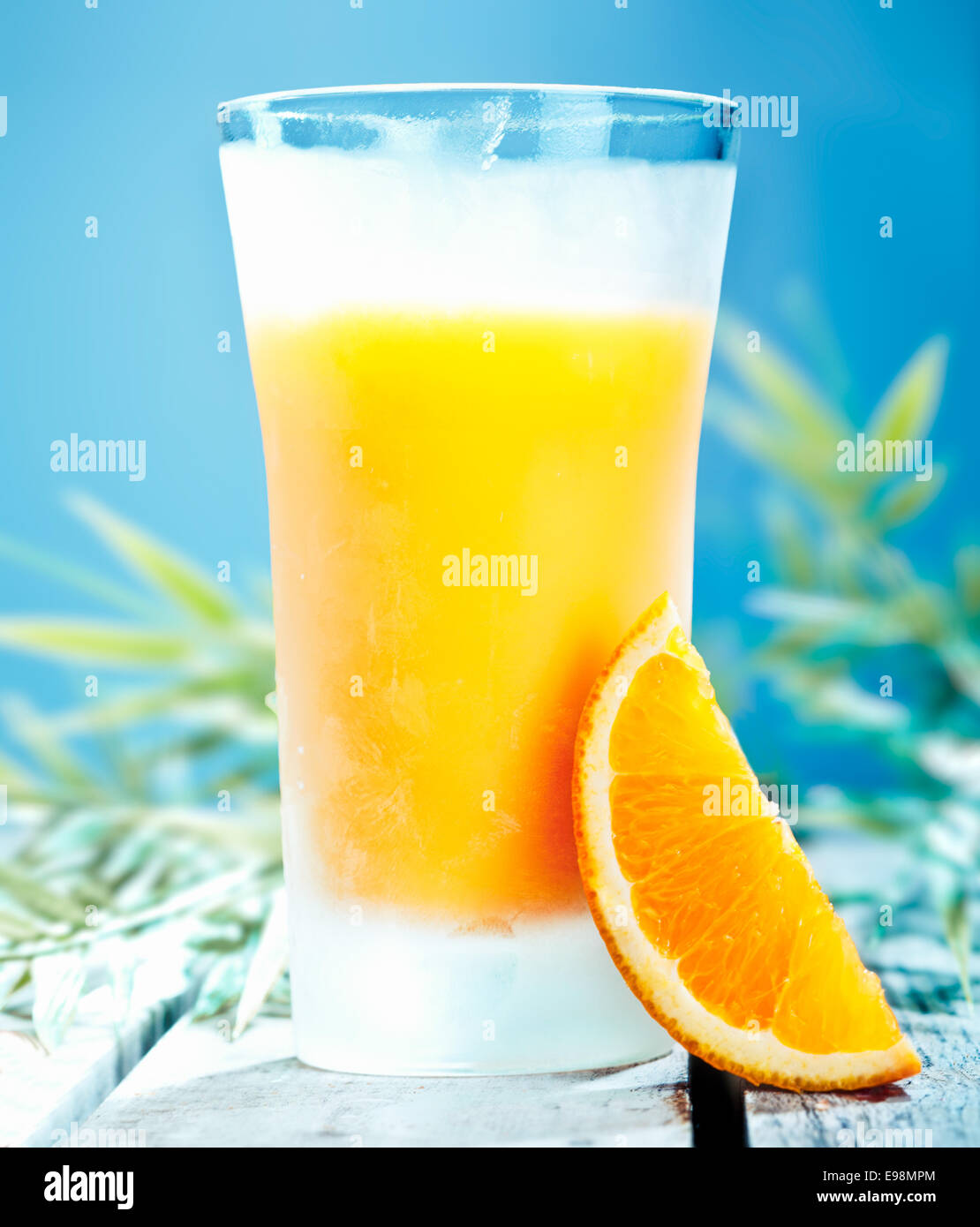 Bicchiere di fresco cocktail all'arancio spremuta fresca contro un Cielo di estate blu Foto Stock